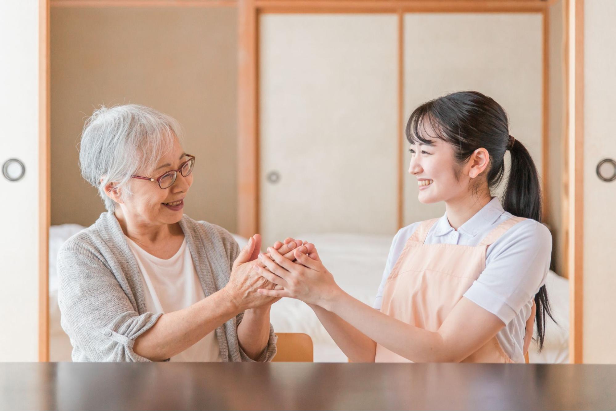 高齢者女性と話す女性スタッフ