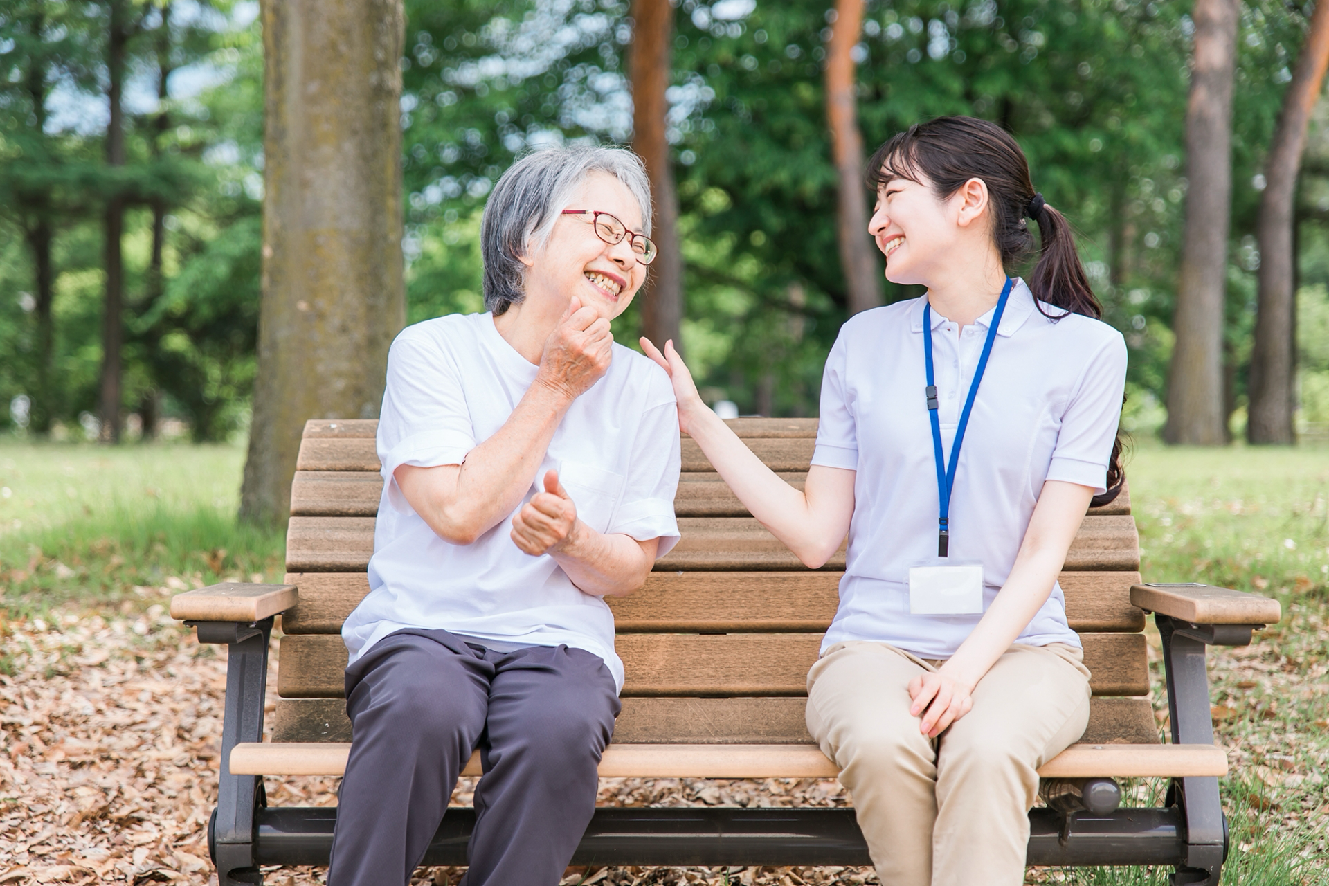公園で話す高齢者と笑顔の介護スタッフ女性