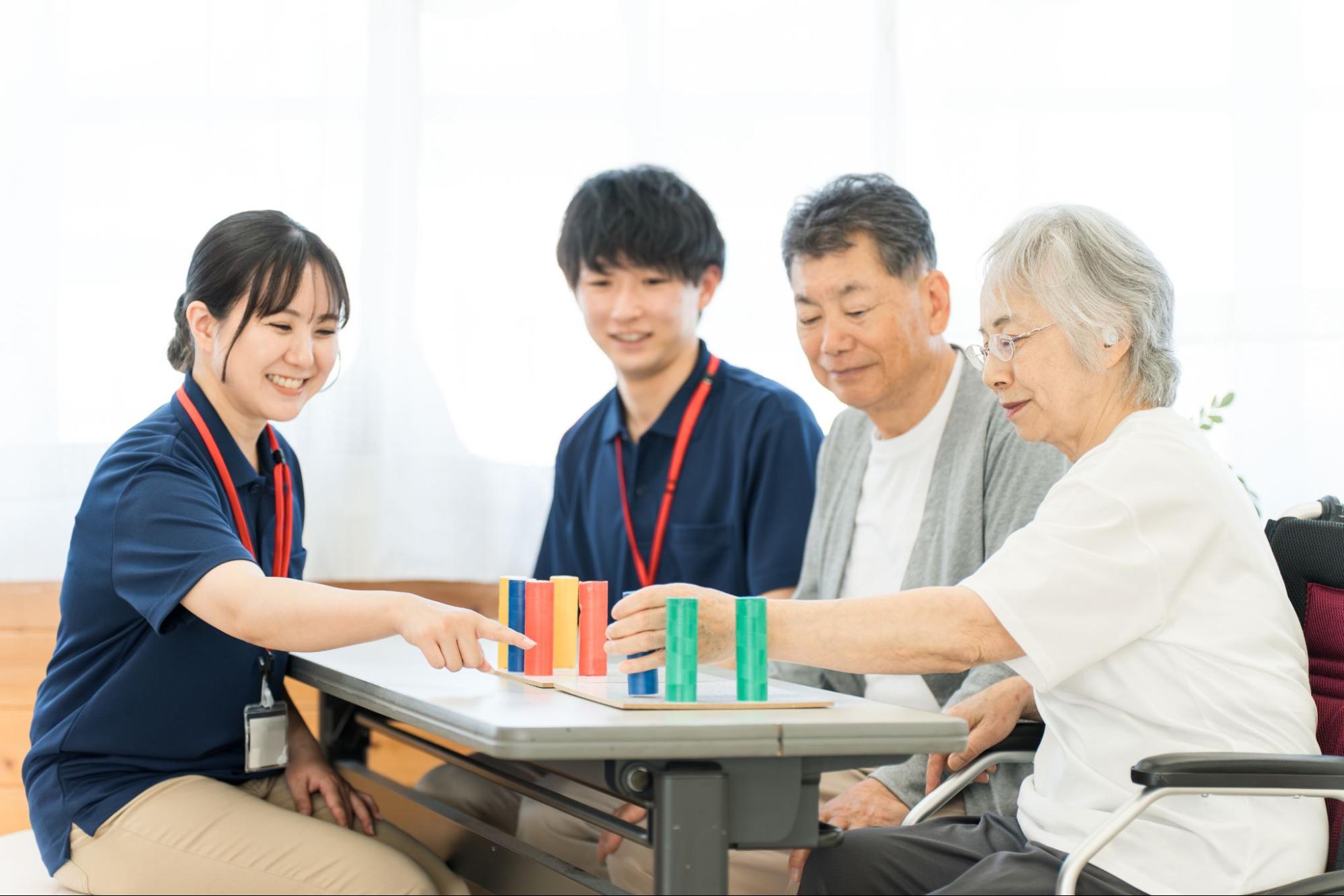 リハビリをするシニア女性と施設で働く職員