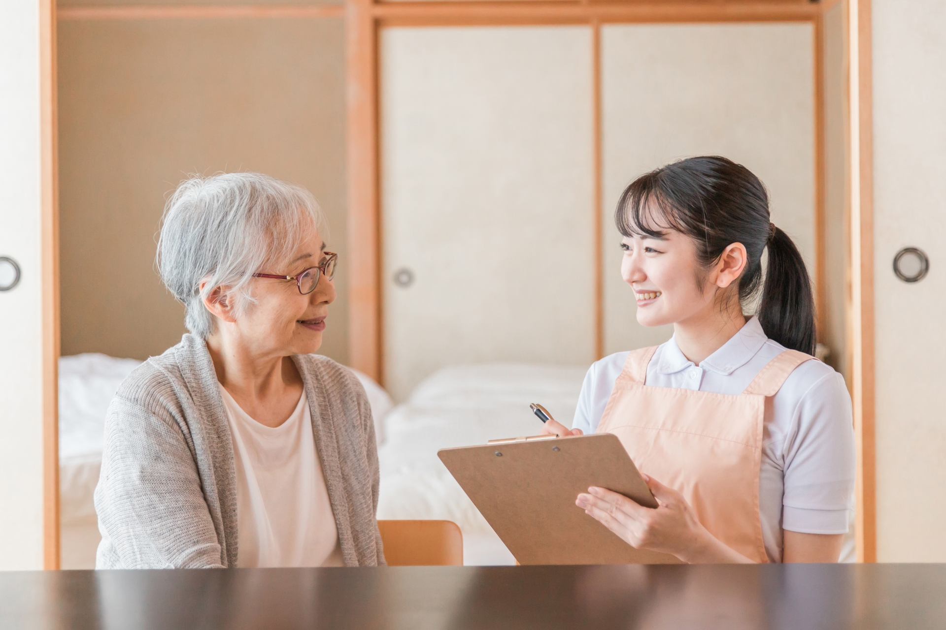 高齢者女性と話す女性スタッフ
