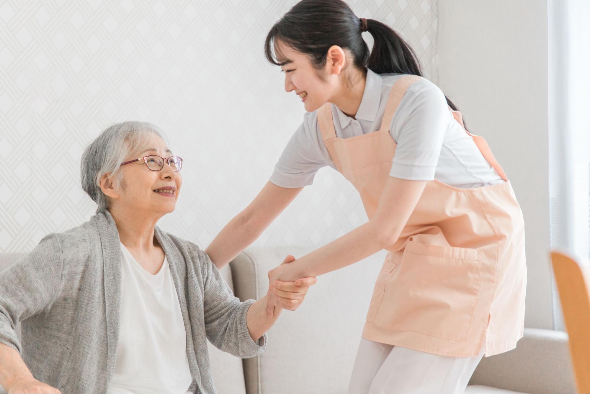訪問介護する女性と高齢者
