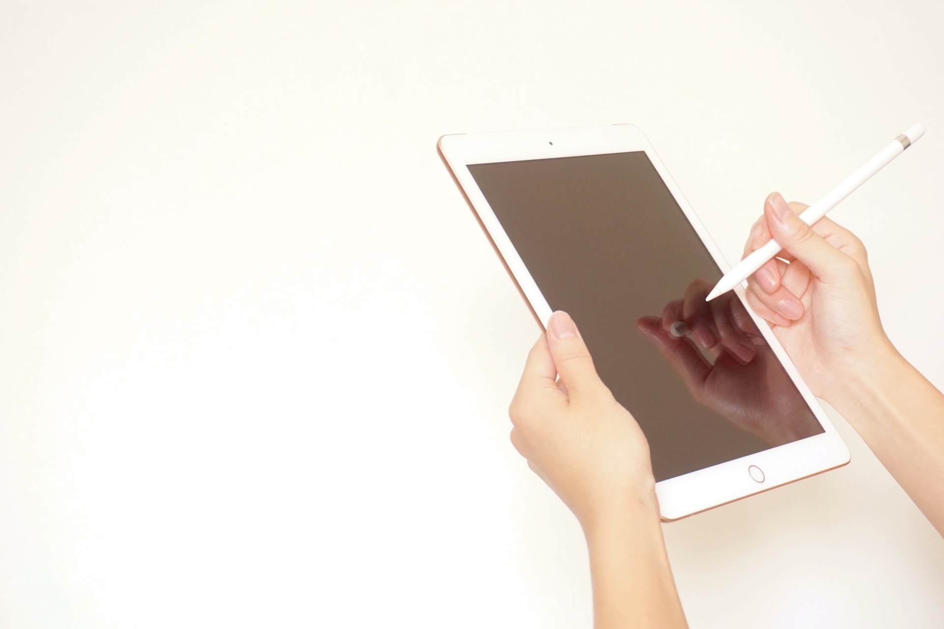 タブレットとペンを持つ女性の手