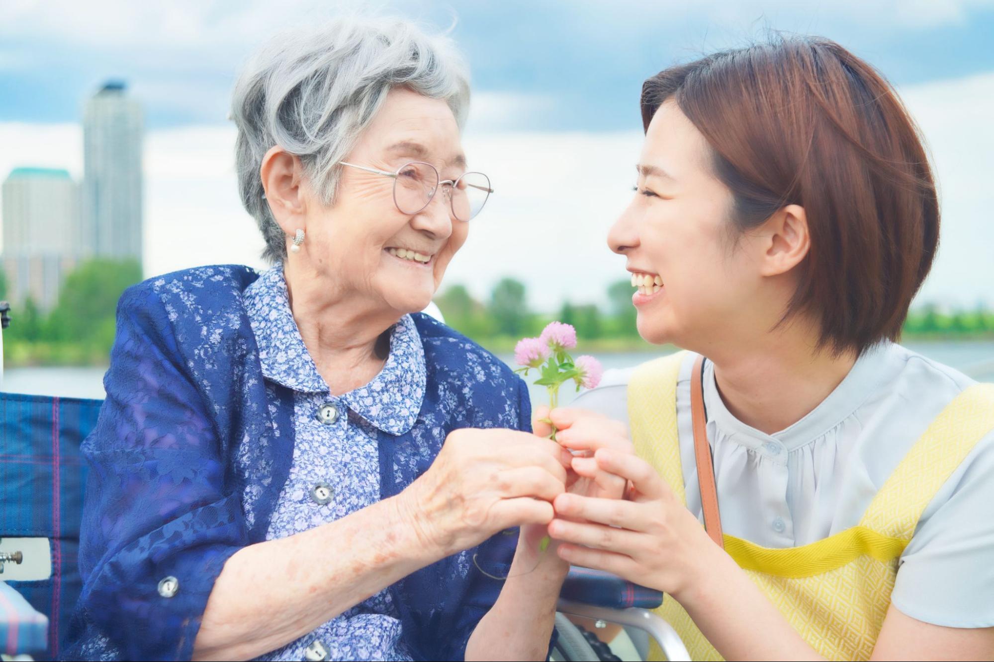 手を握って高齢者と話すヘルパー