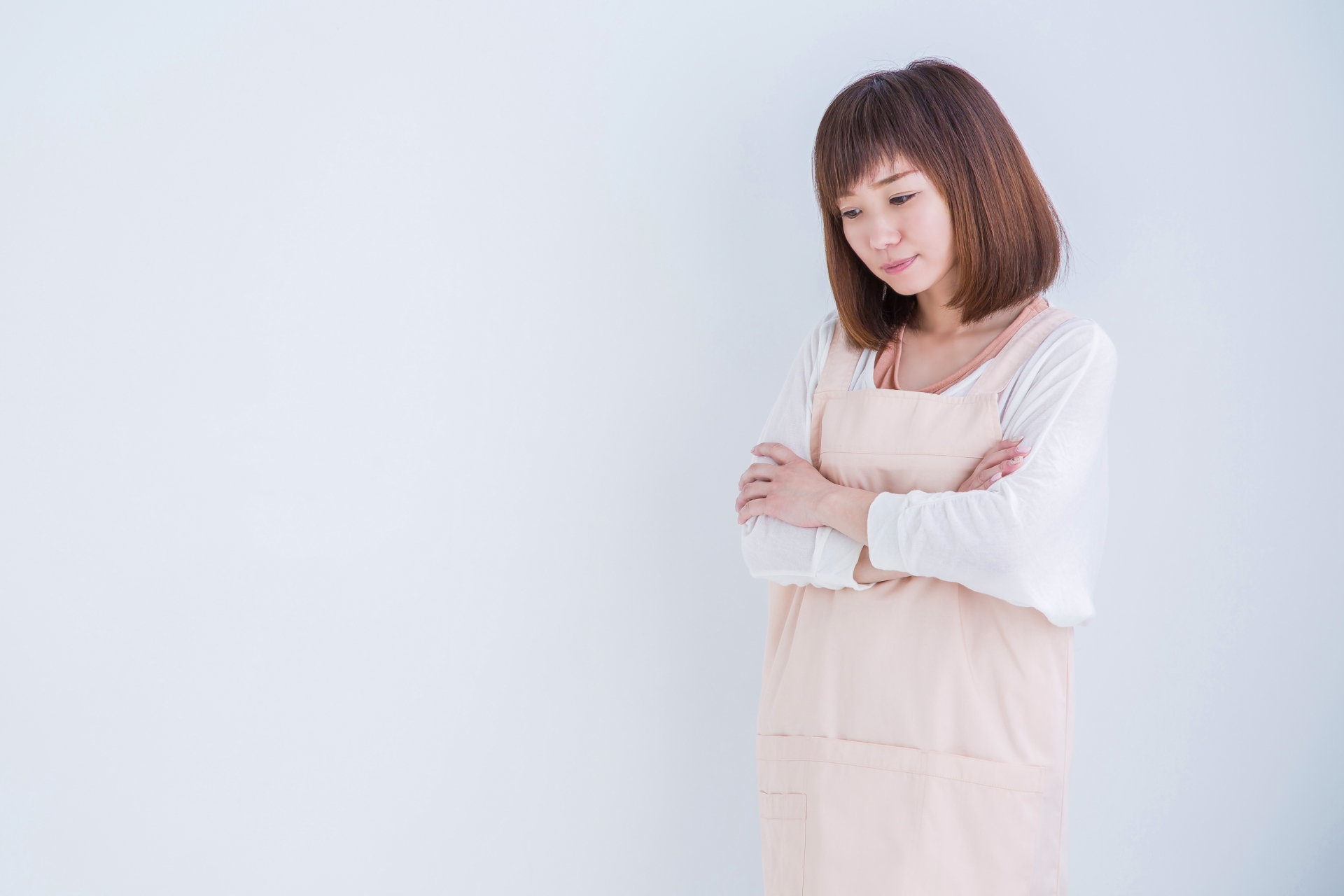 考えるエプロン姿の女性