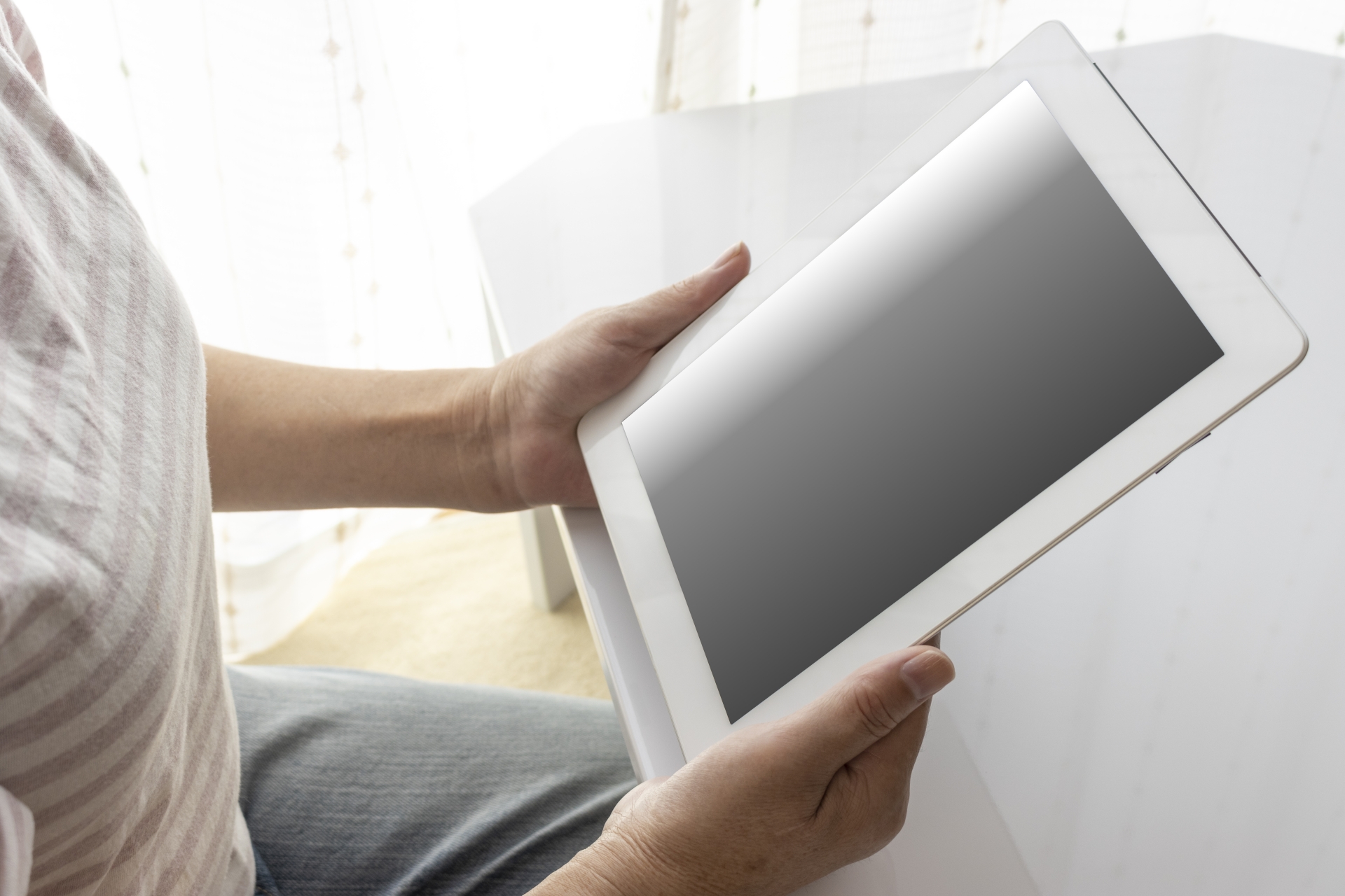 タブレット端末を使うシニア女性の手元（日本人、60代）