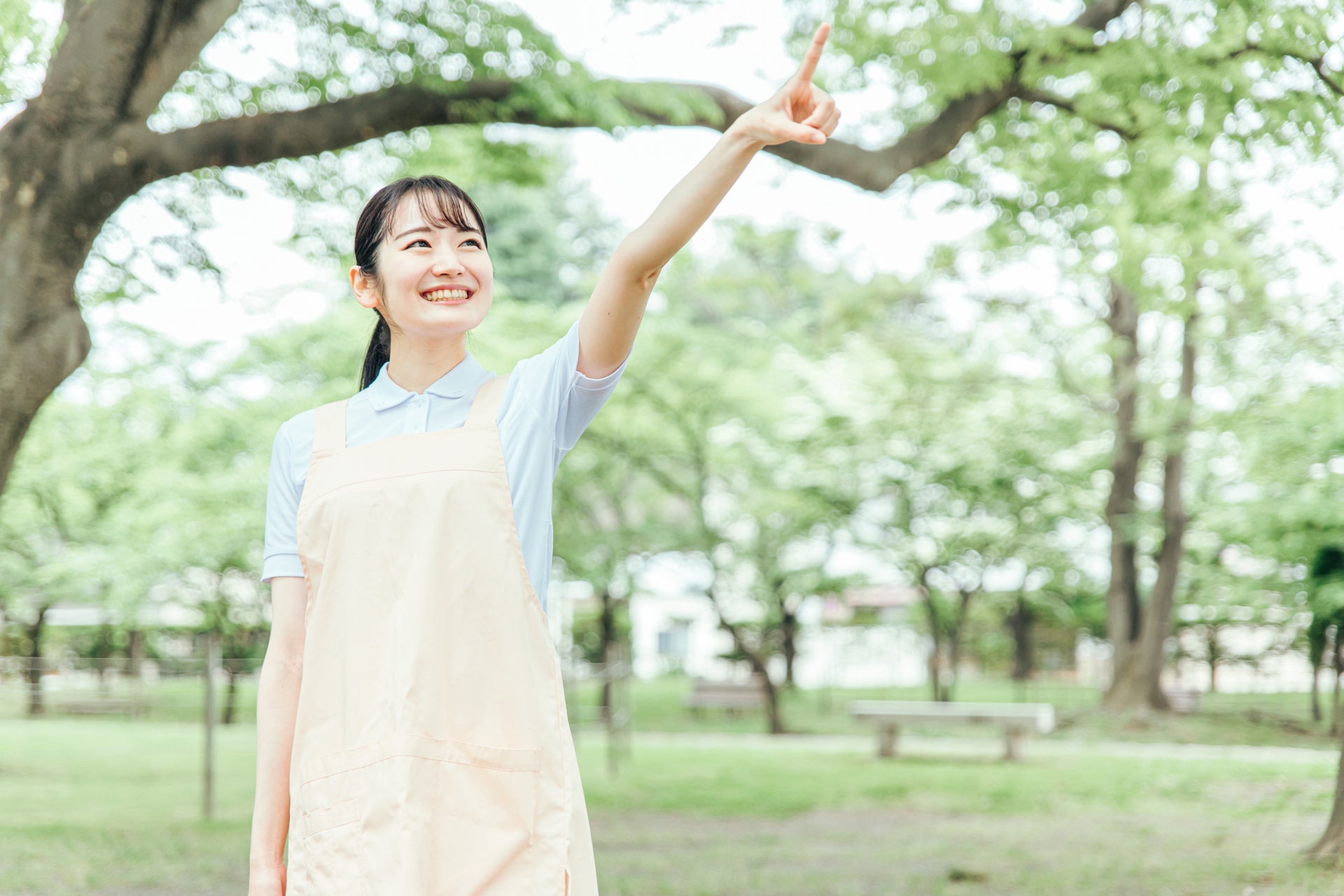 医療・介護・福祉系の女性スタッフ(指差す)