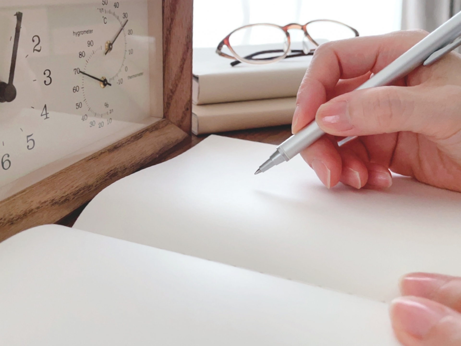 ノートに字を書く女性の手