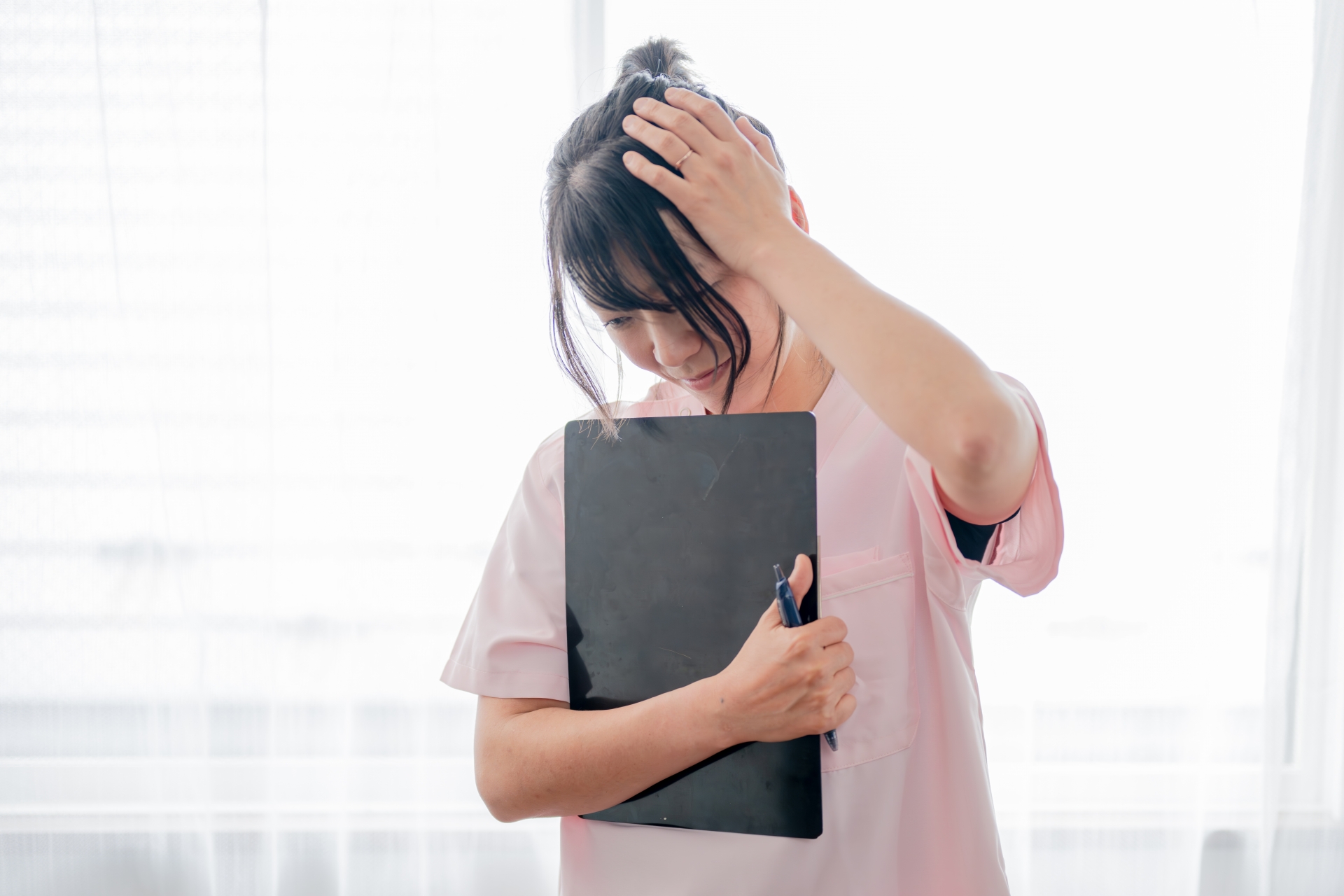 頭を抱える若い医療系女性