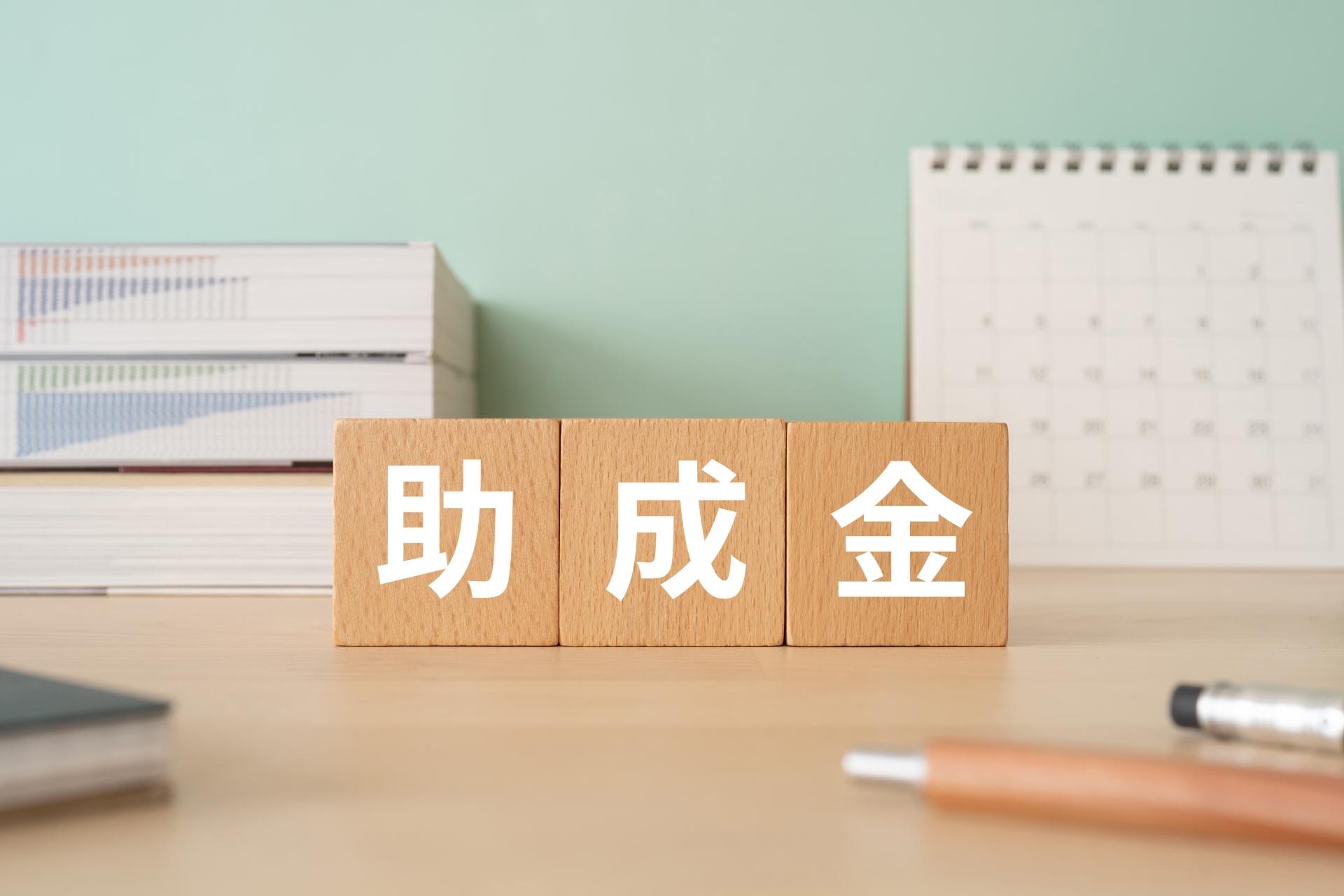 助成金と書かれたブロックが置かれたデスク