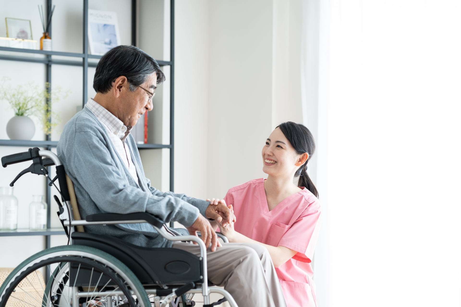 車椅子のシニアの男性と介護福祉士