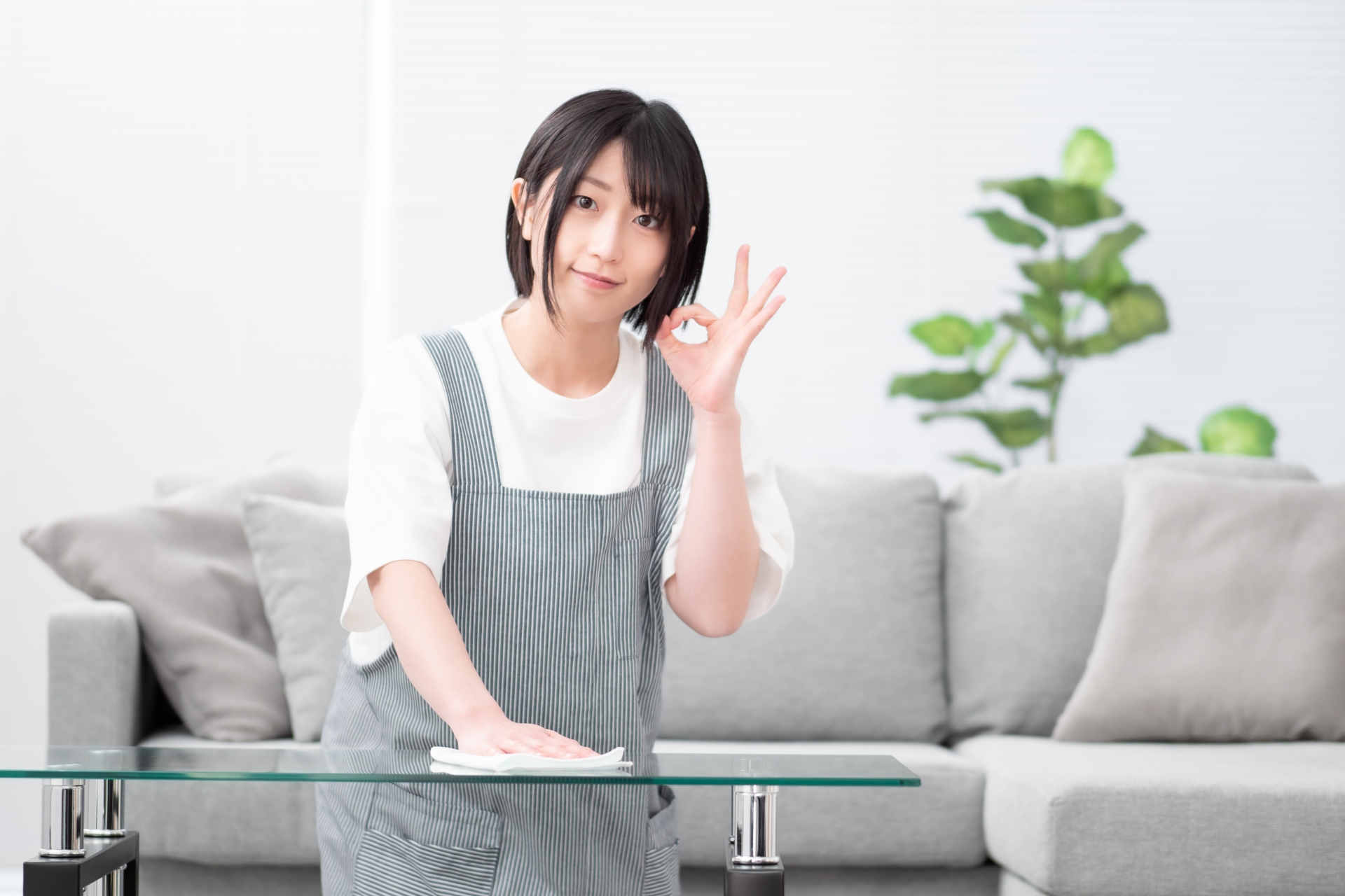 テーブルを拭き掃除する若い女性のイメージ