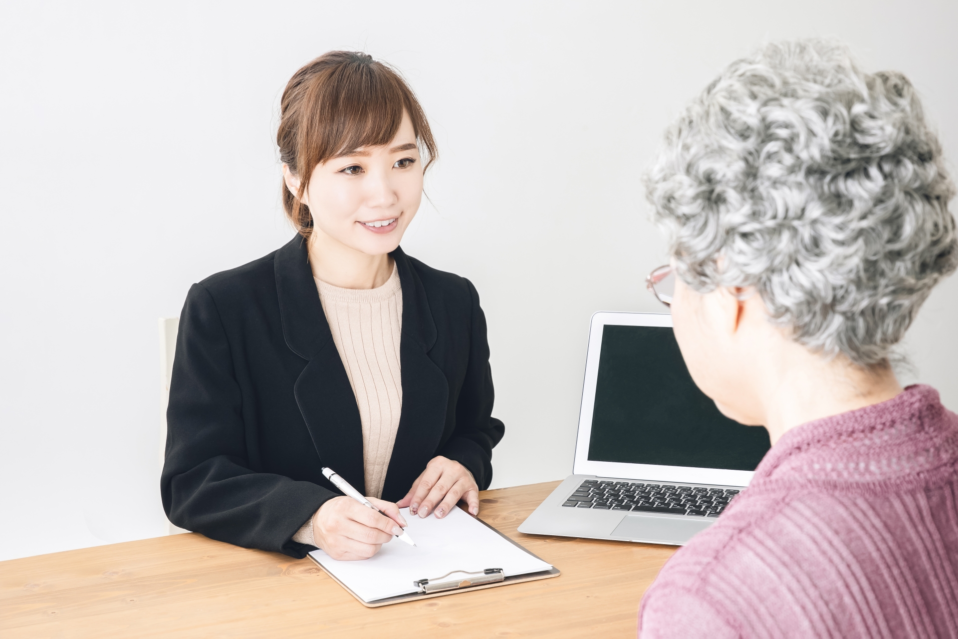 スーツ姿の女性と高齢者