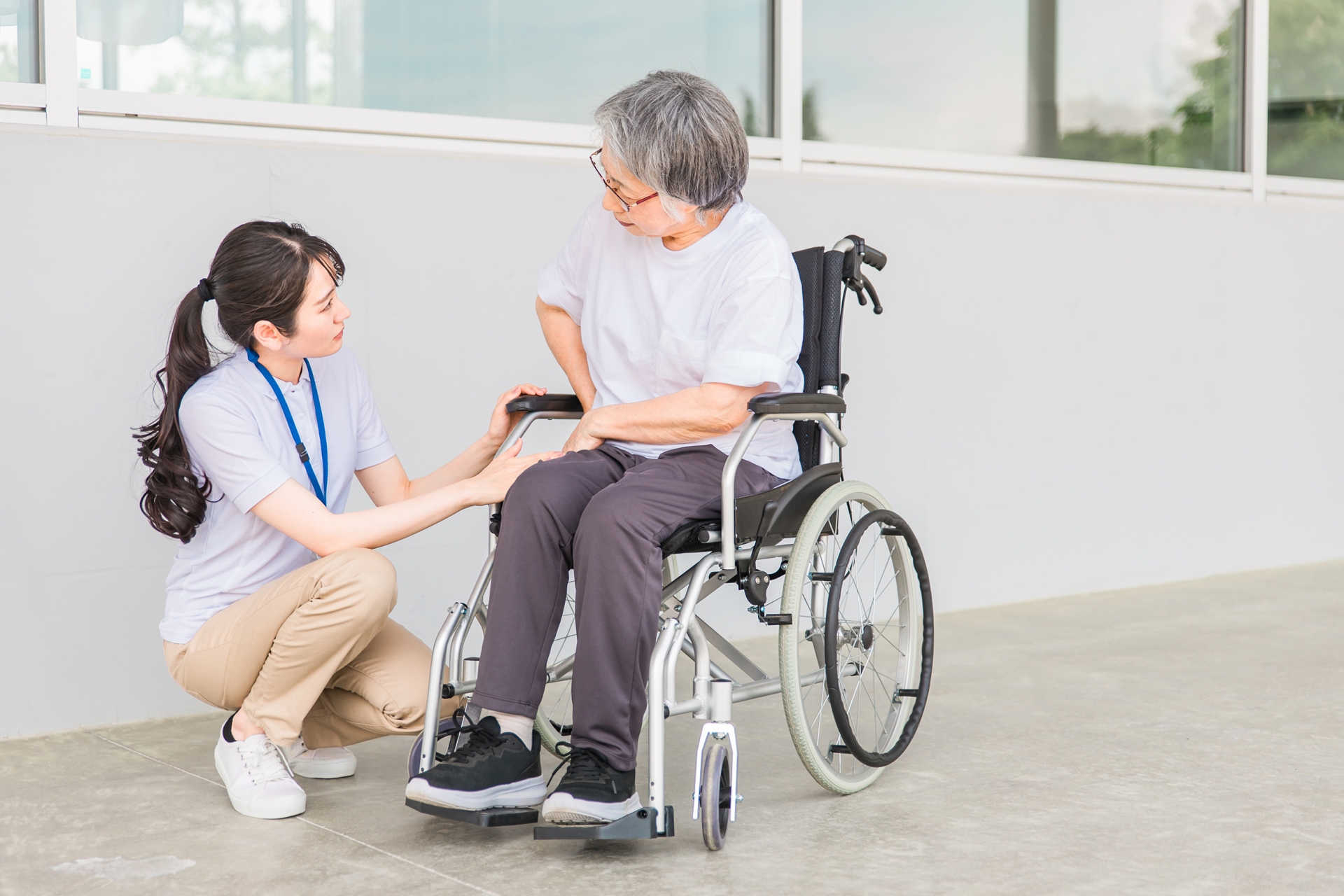 車椅子に乗る高齢者と介護士(股関節)