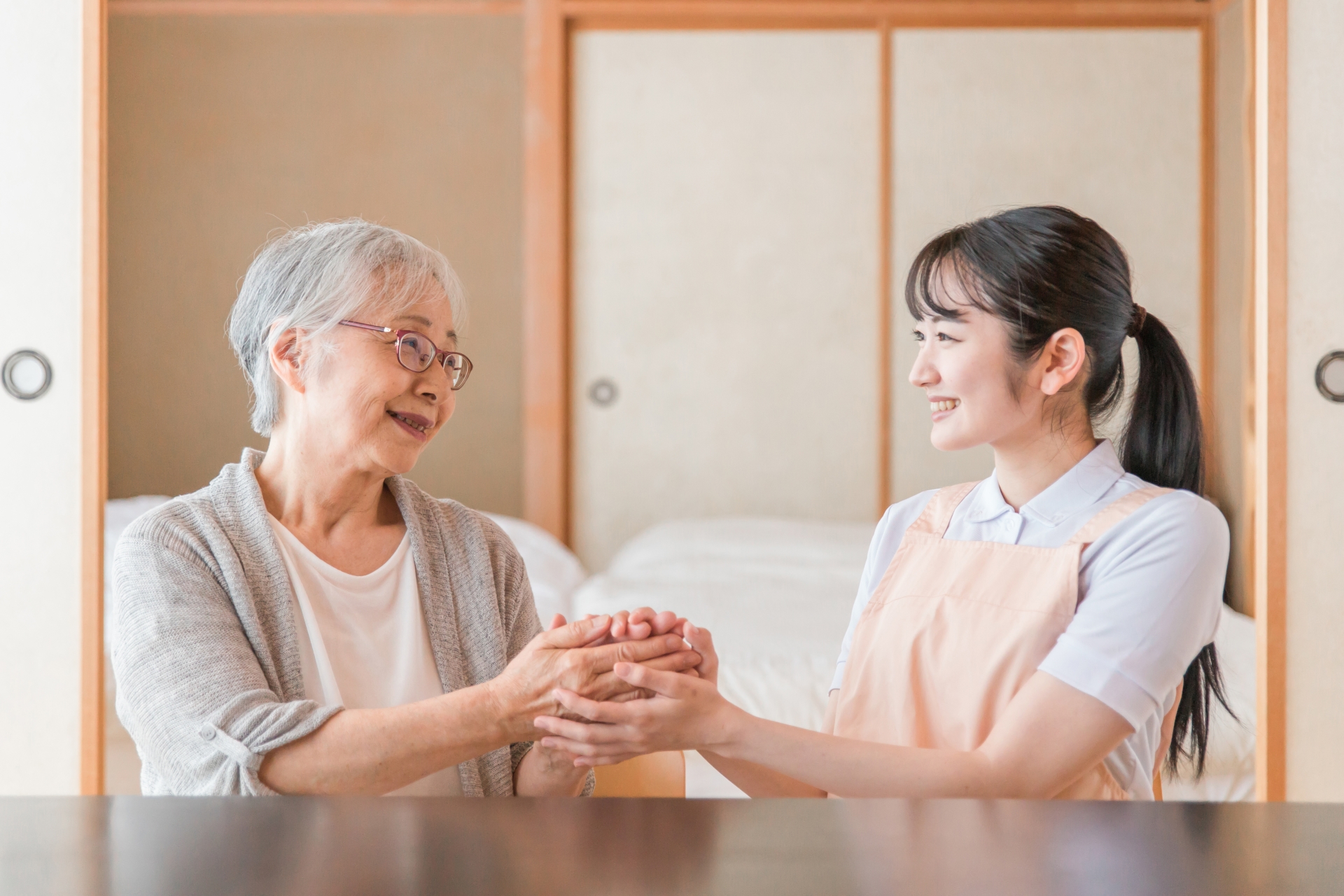 高齢者女性と話す女性スタッフ