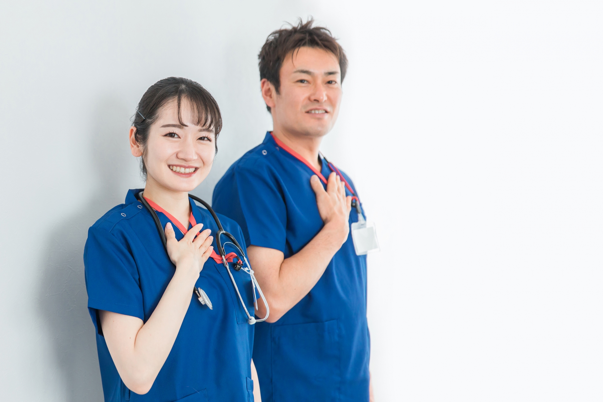 青いユニフォームを着た医療従事者の男女