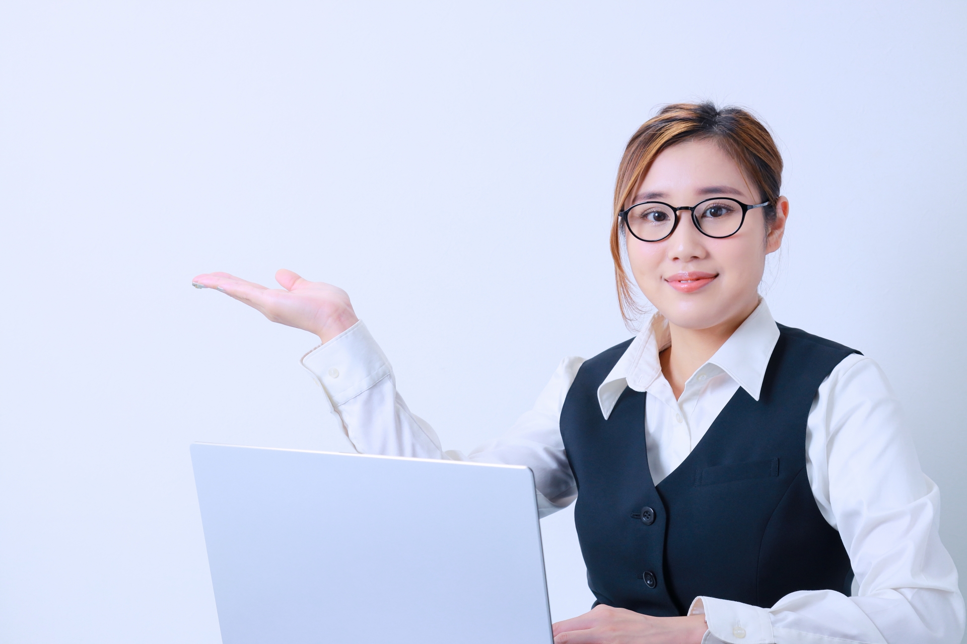 案内をするポーズをとる若い女性社員