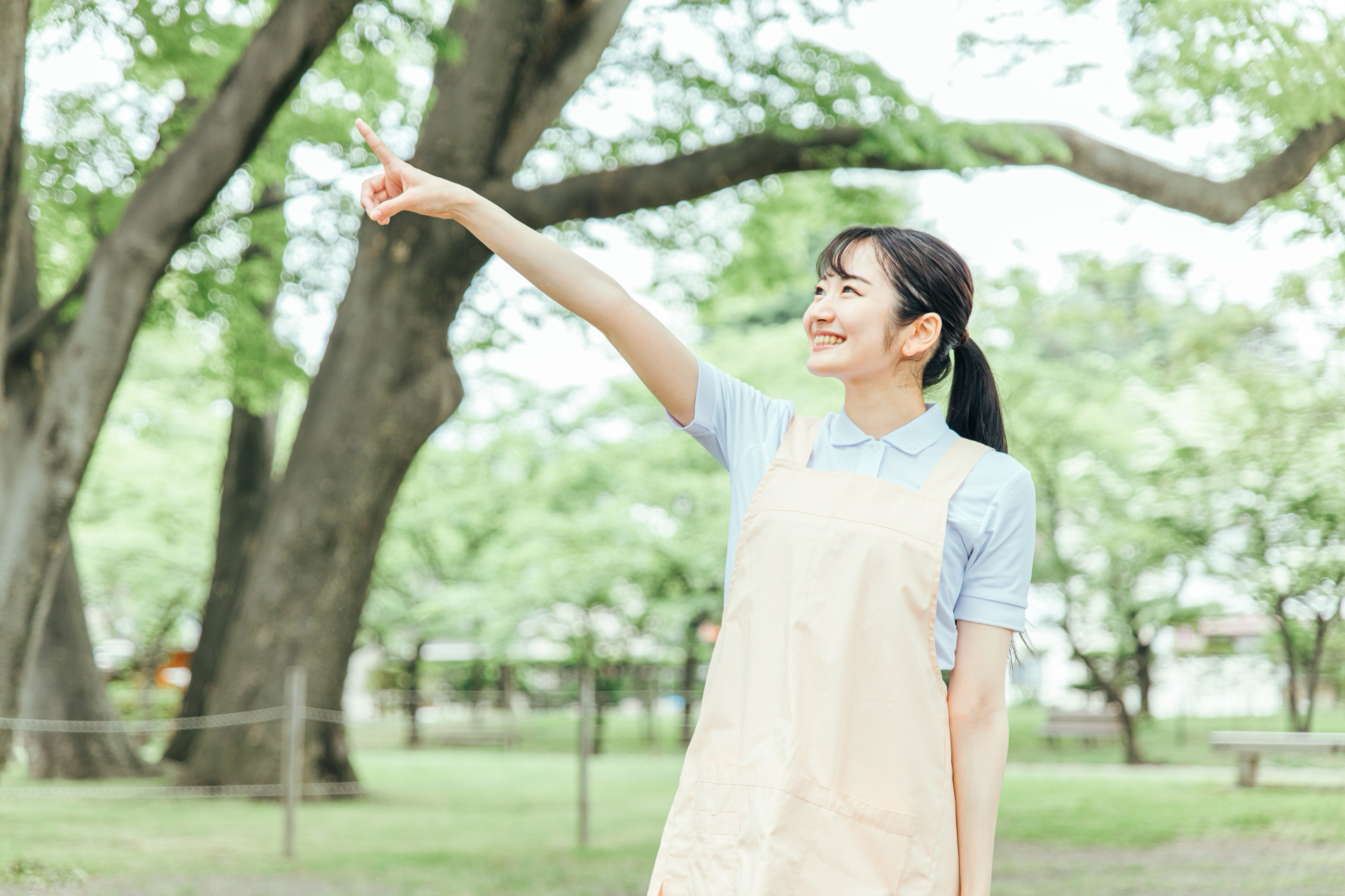 医療・介護・福祉系の女性スタッフ(指差す)