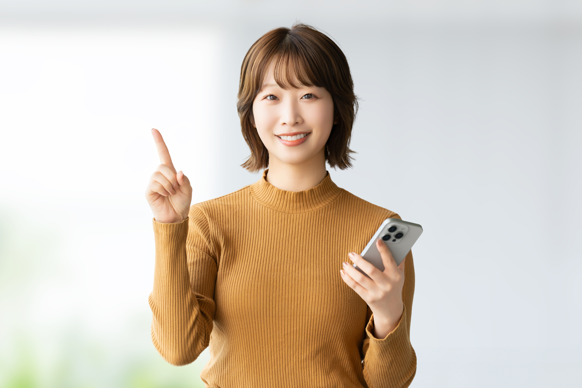 スマホを持って案内をする笑顔の女性