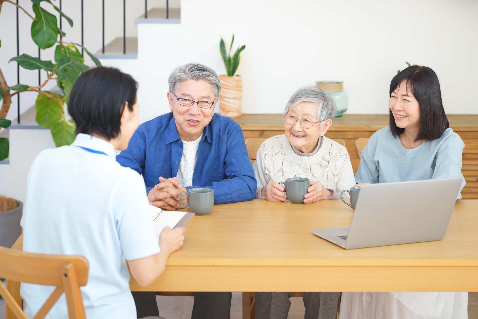 介護士に相談する高齢女性と家族
