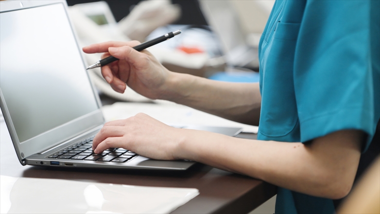 事務仕事をするアジア人介護士の手元