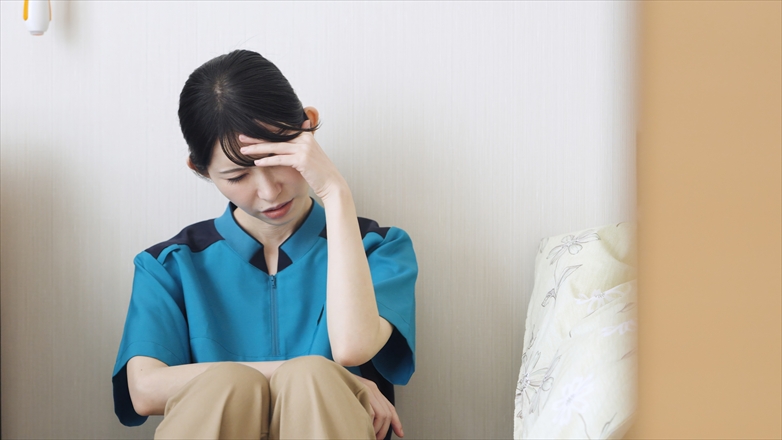 介護の仕事で疲れるアジア人介護士