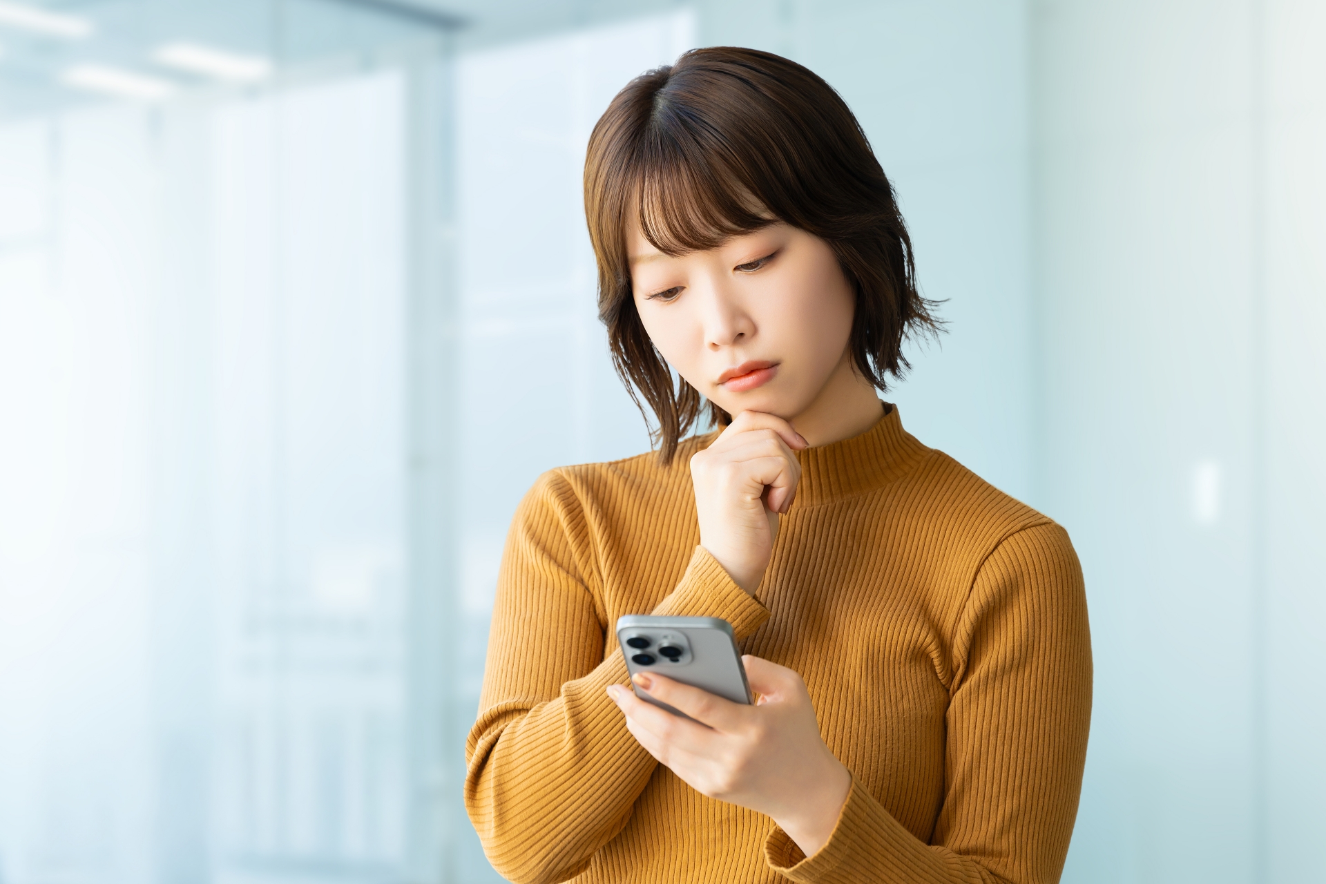 スマホを見て考える女性・ビジネスウーマン
