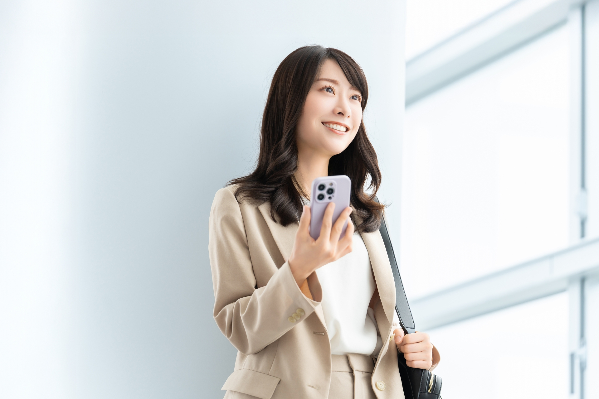 スマホを持つ笑顔の女性・ビジネスウーマン
