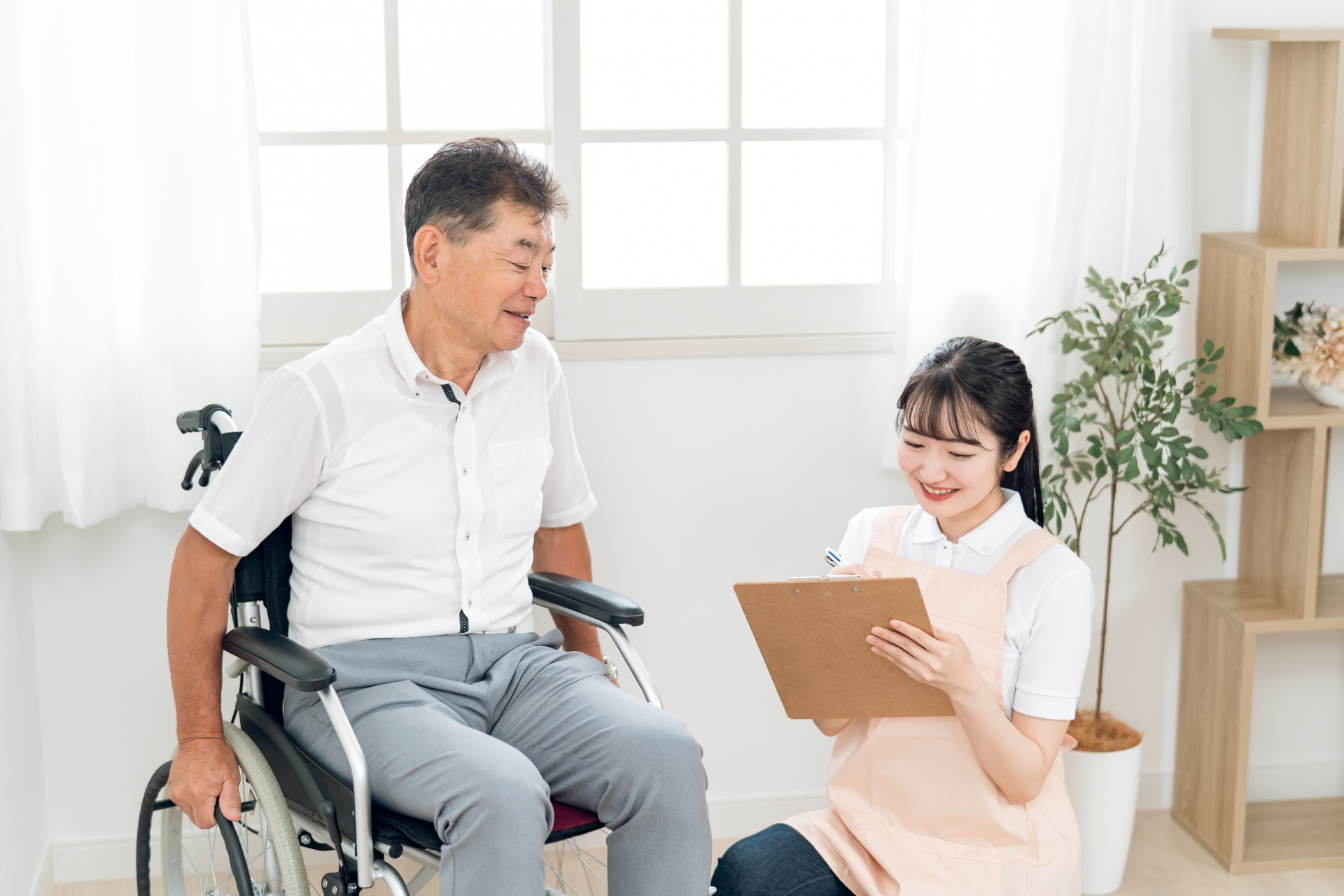 高齢者女性と話す介護士(メモ)