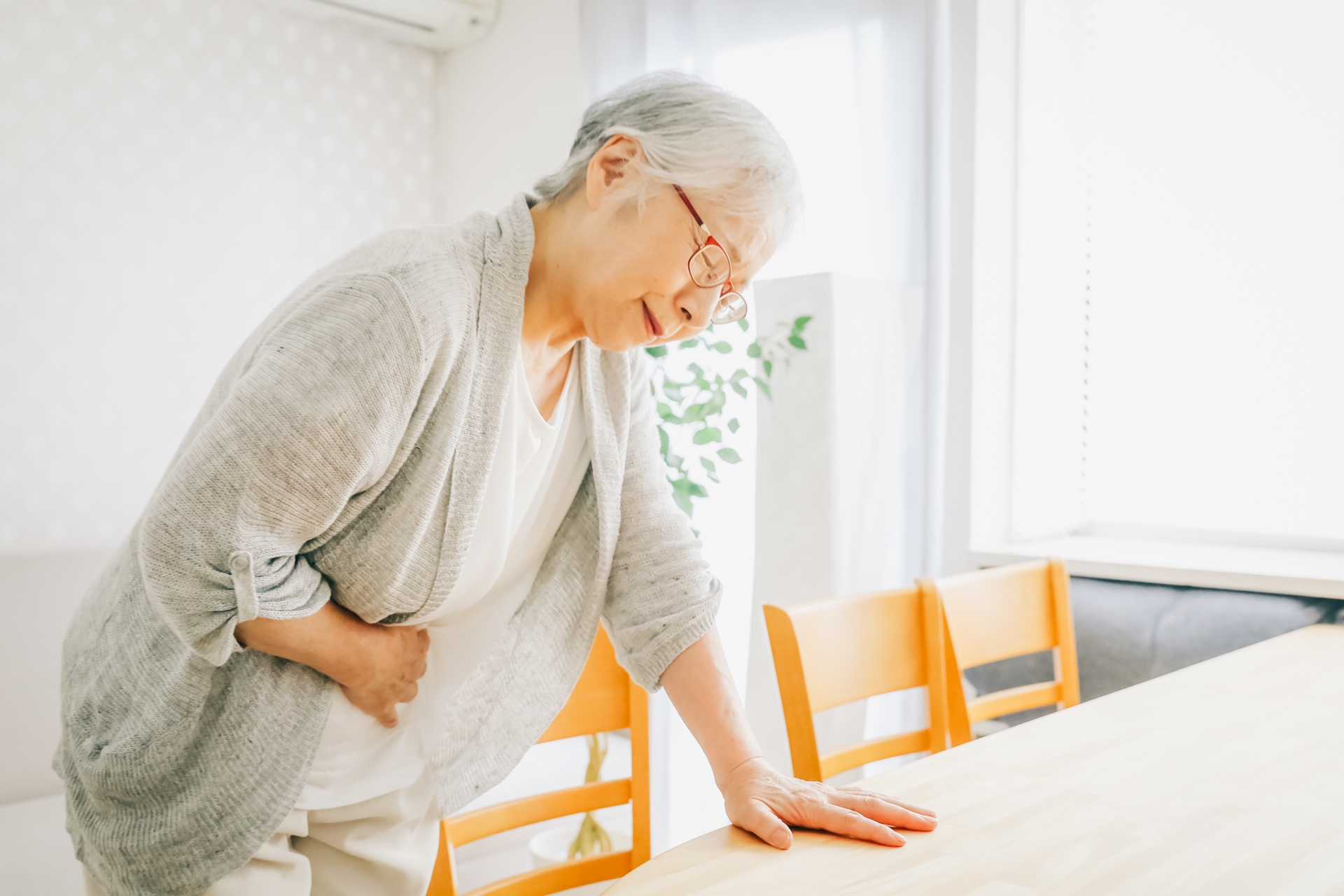 お腹が痛い高齢者女性