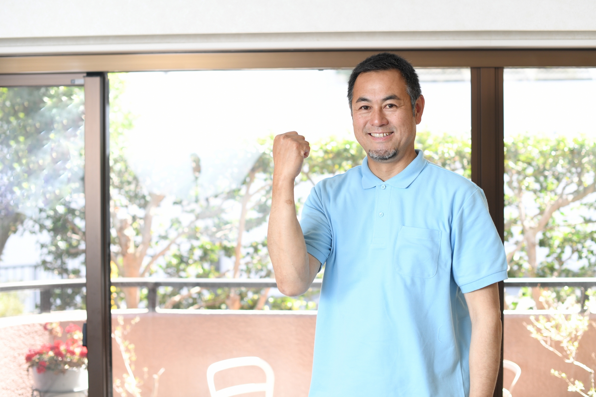 ガッツポーズをする笑顔の男性介護士