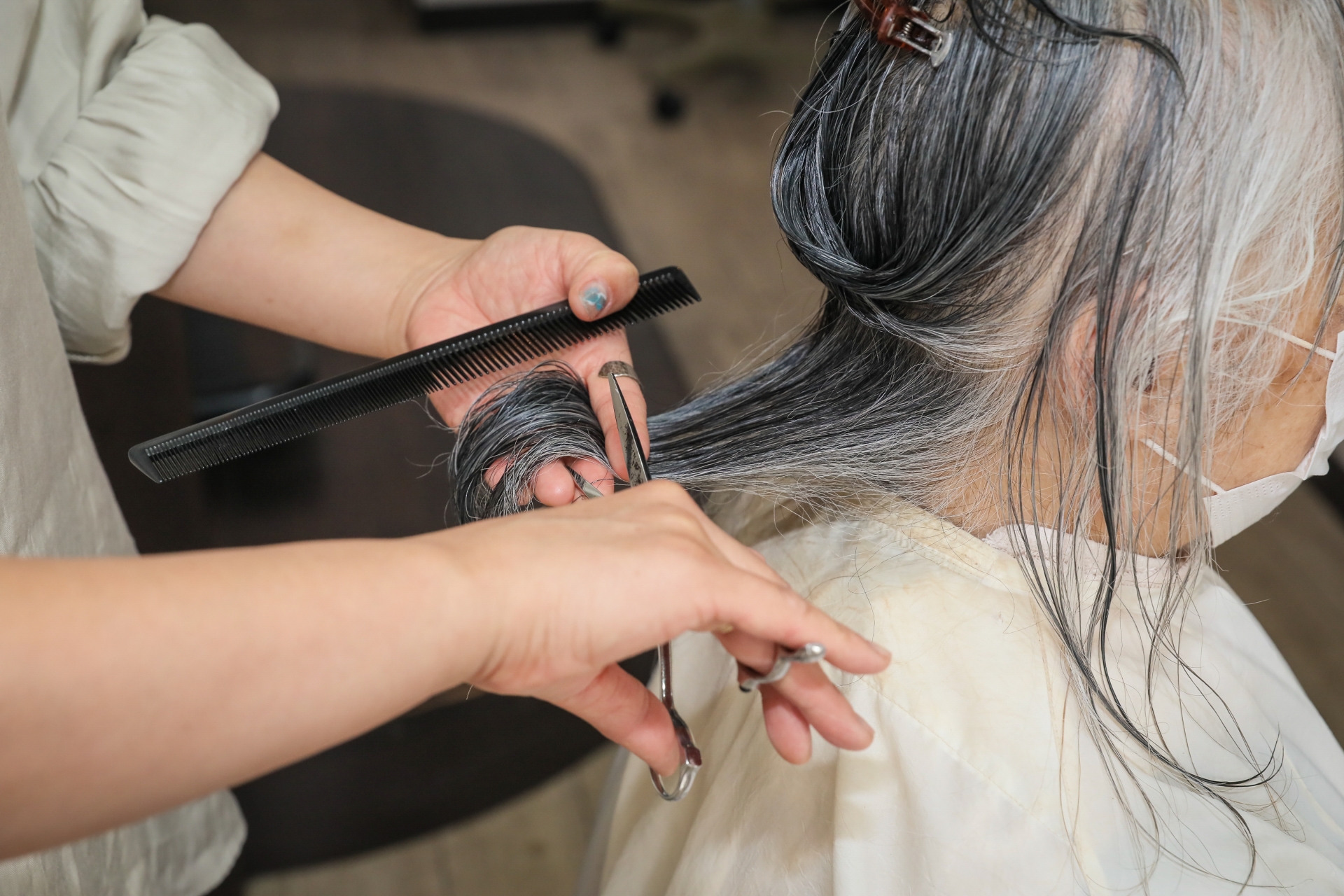 高齢者のヘアカットをする美容師(手元)