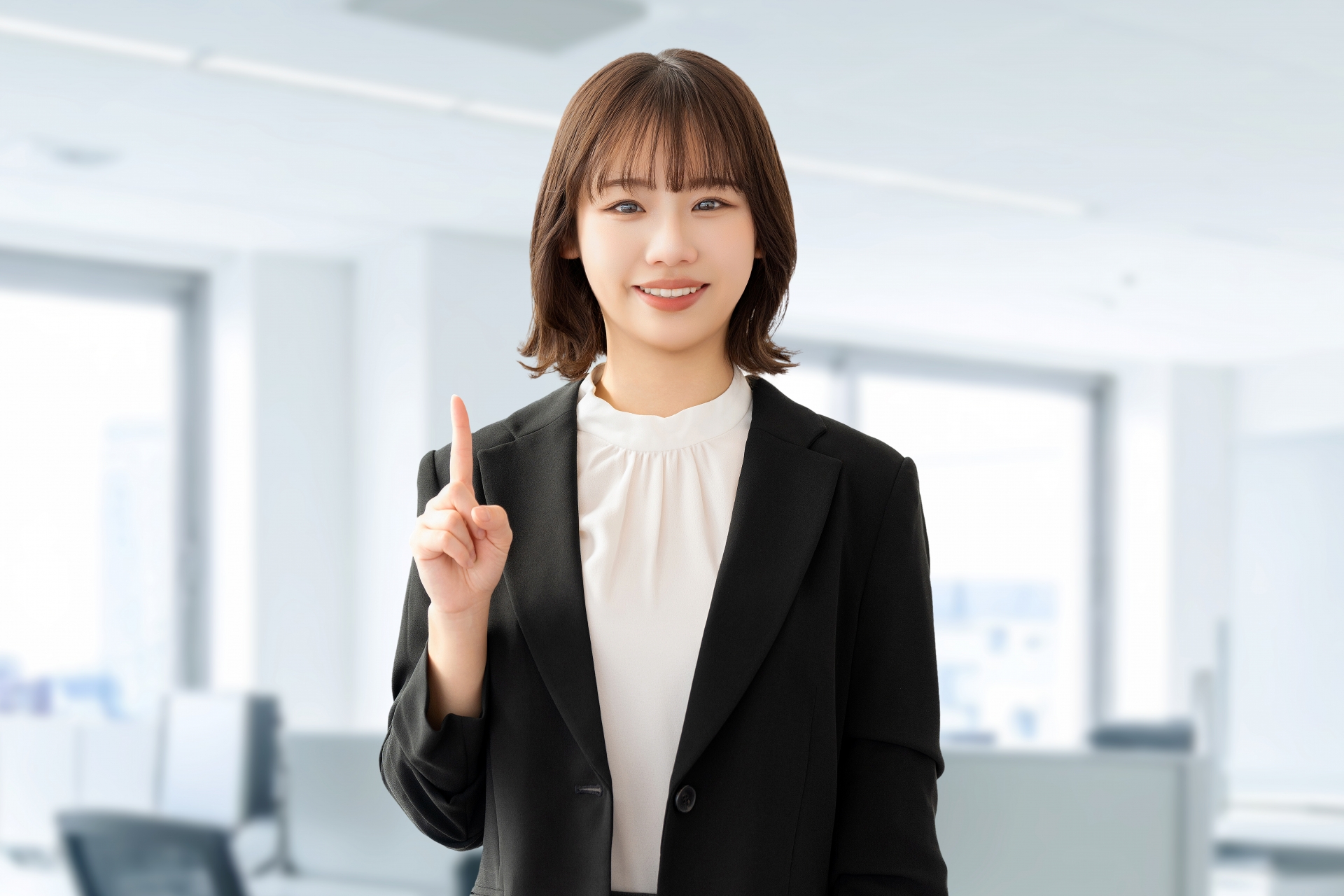 人差し指を立てて案内する笑顔の女性