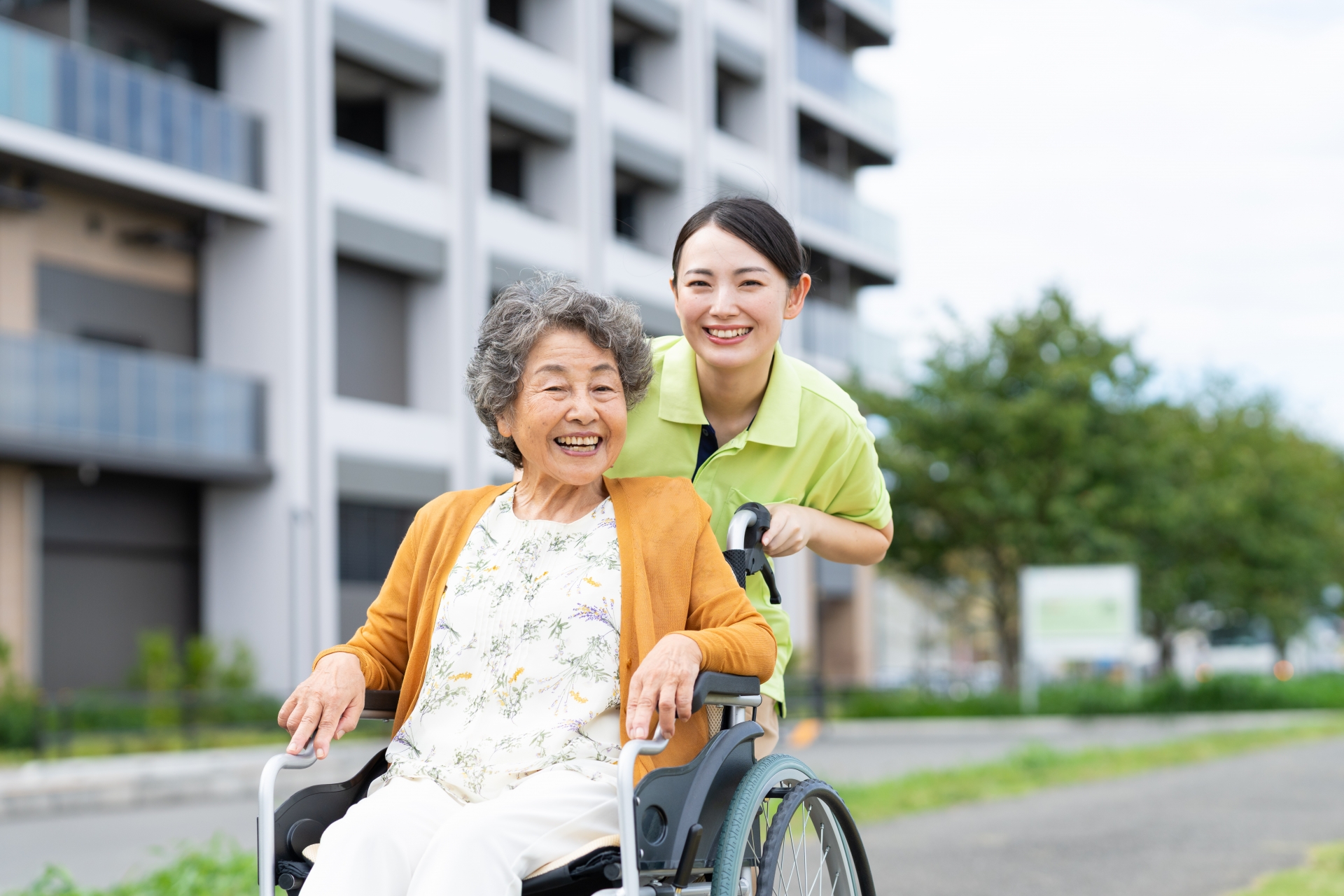 車椅子のシニアの夫婦と介護福祉士