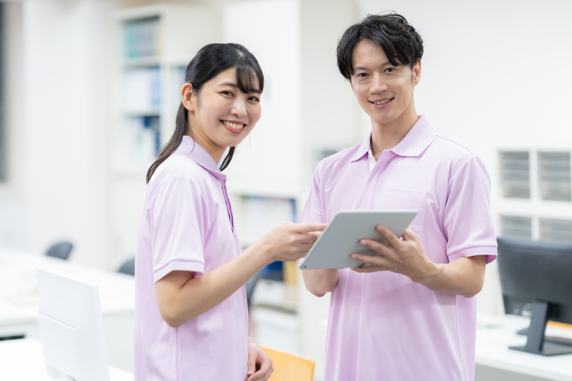 介護施設の事務所の若い男女の介護士
