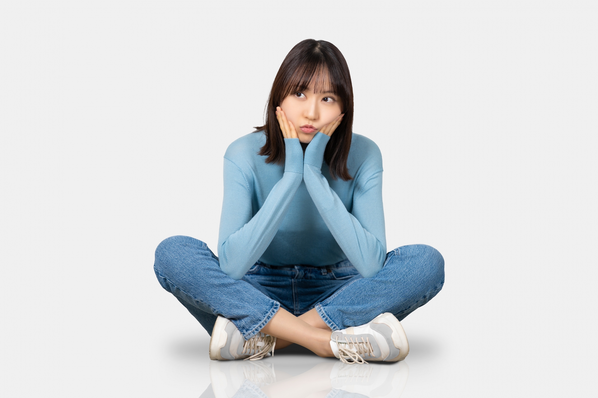 座って考えごとをする女性
