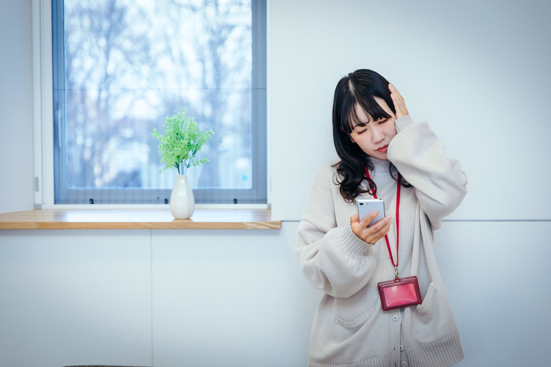 スマホを見て頭を抱える女性