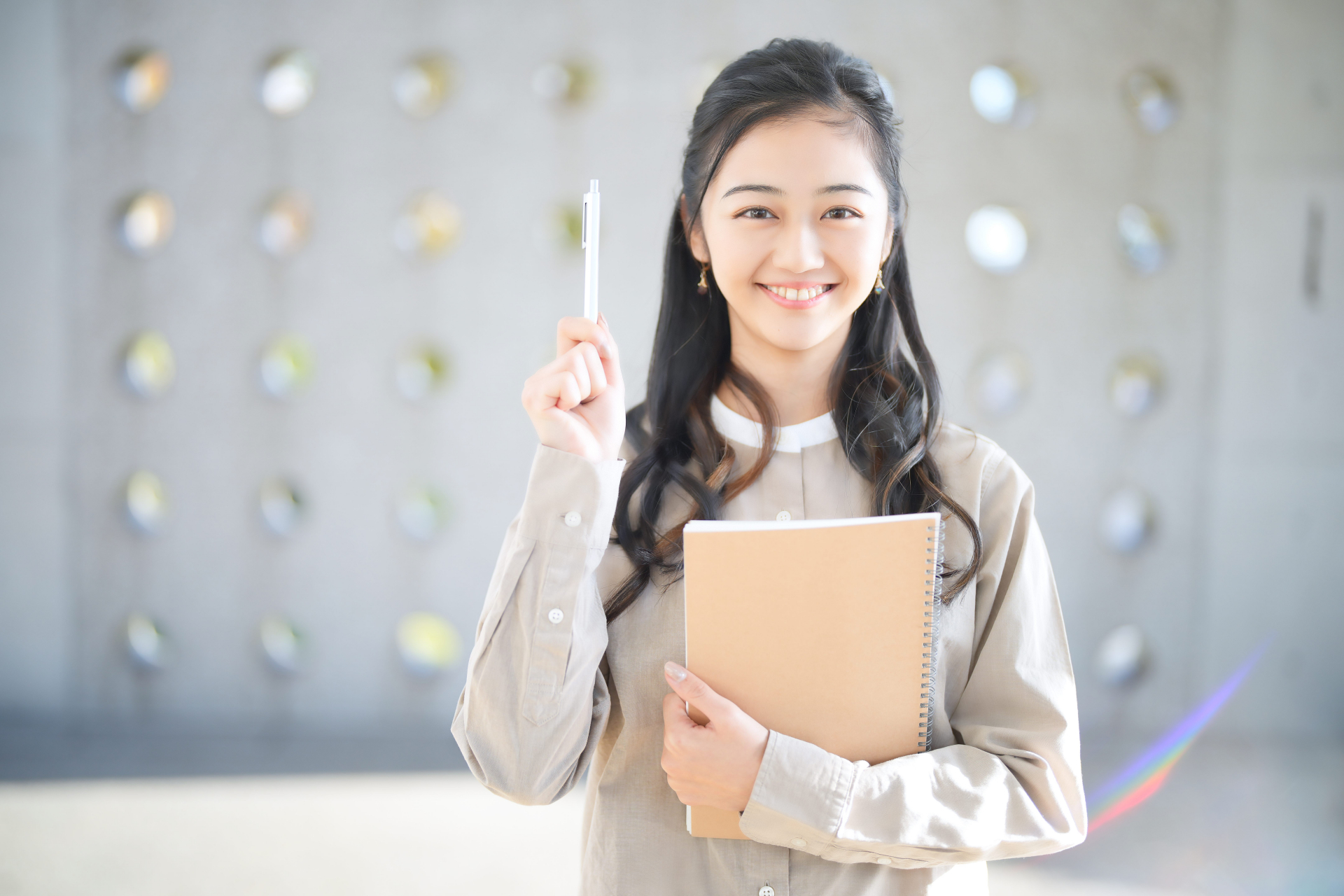 ペンを持ち笑顔の女性