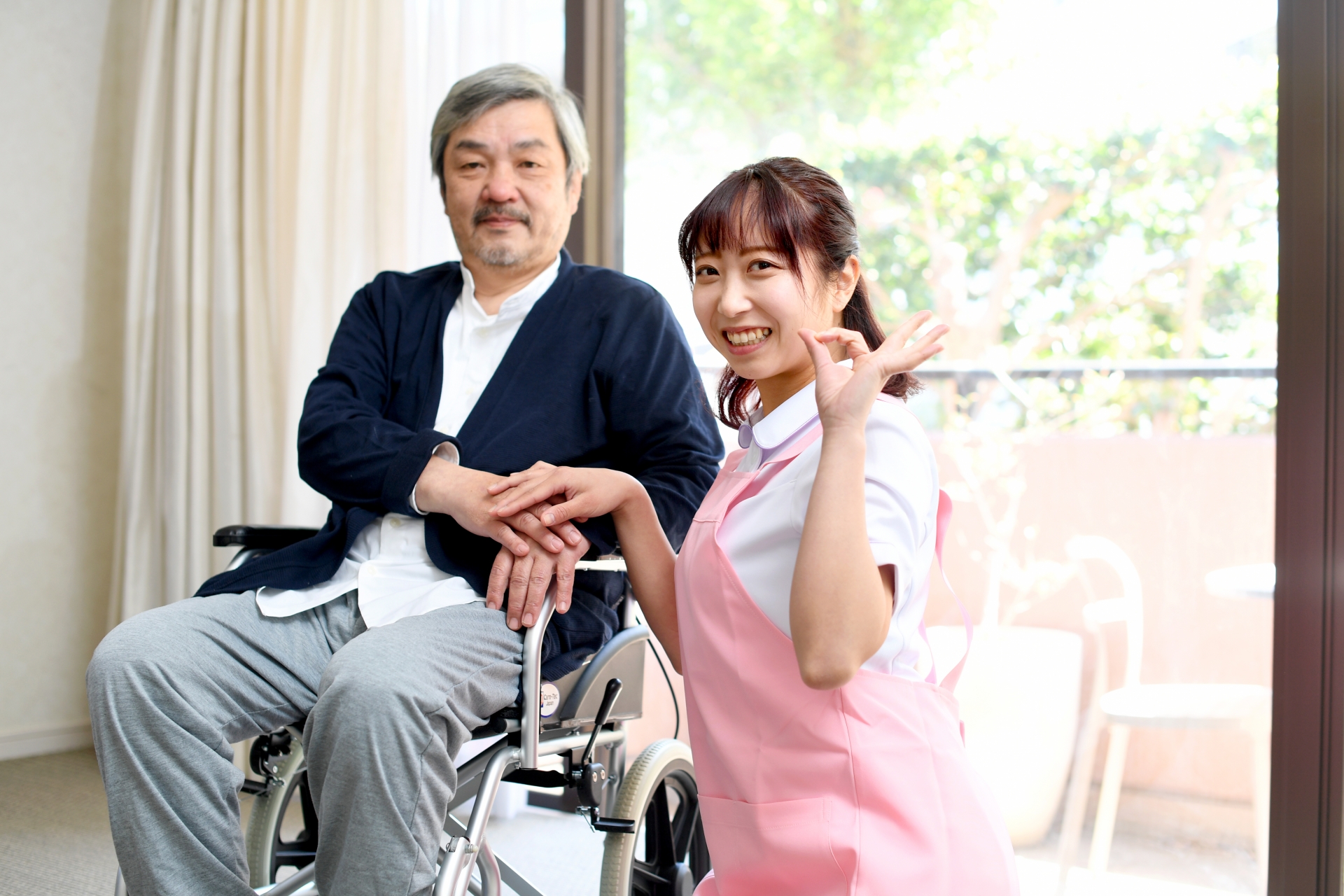 車椅子に乗る高齢者男性と女性の介護士