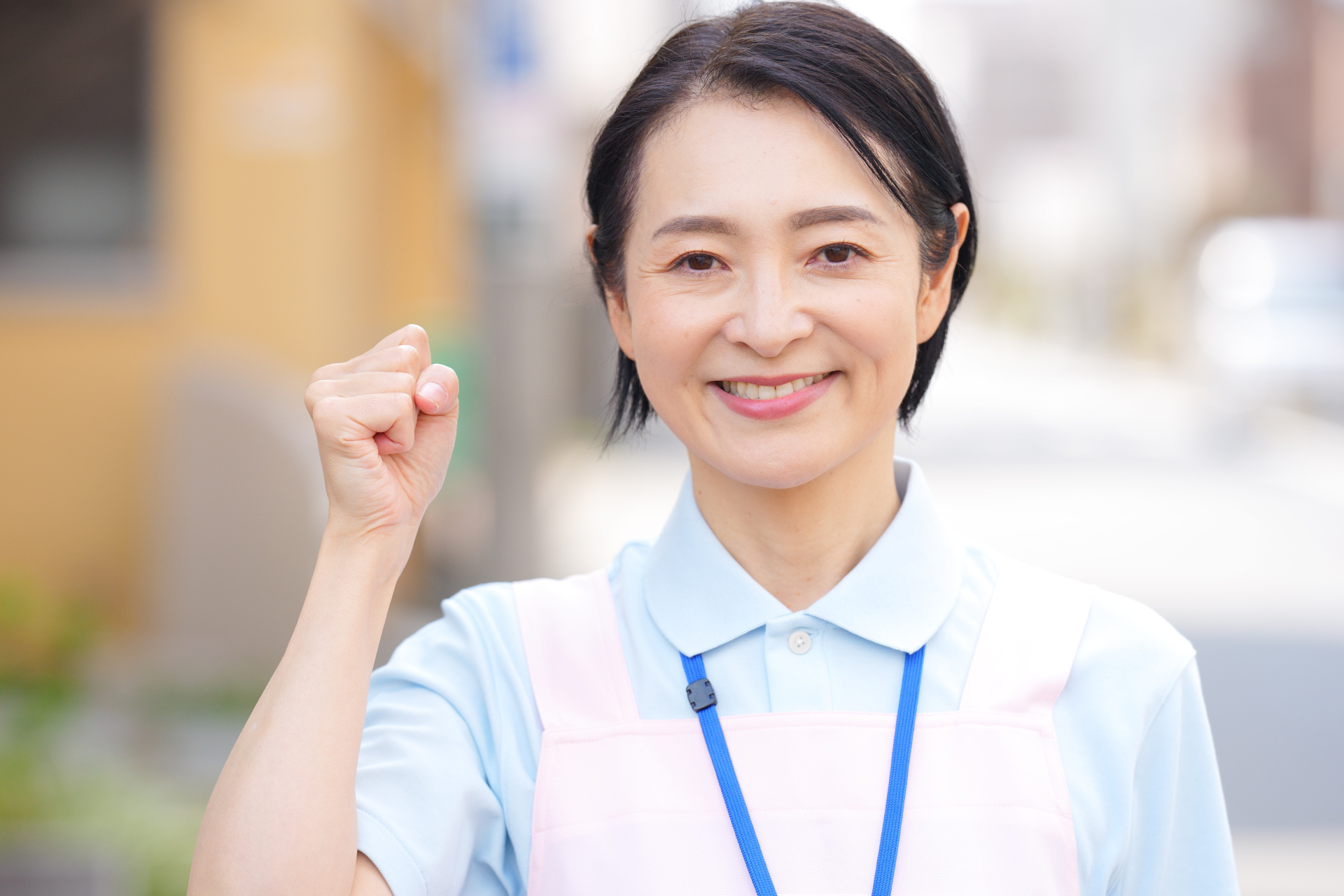 屋外でガッツポーズする女性介護士