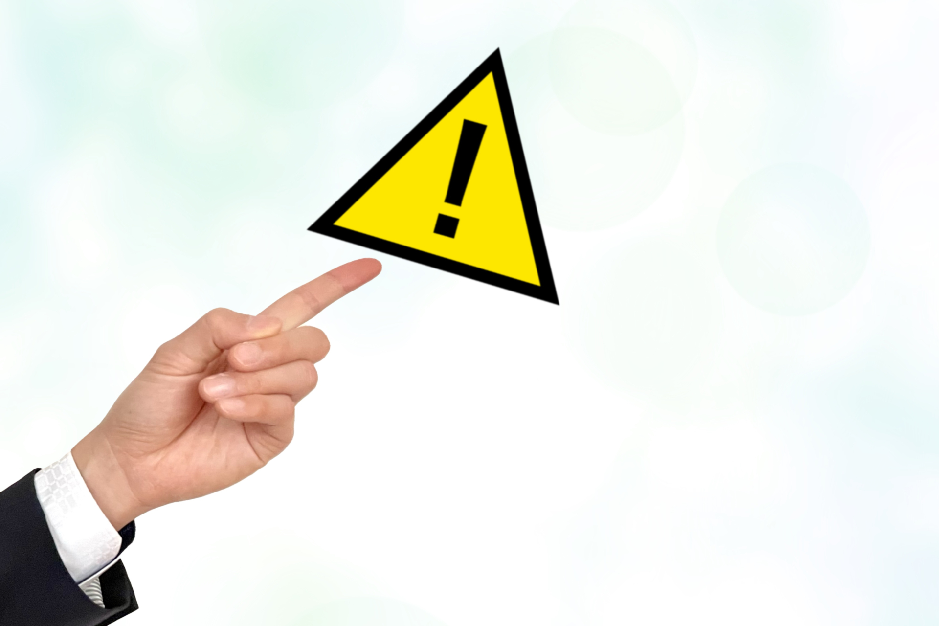 注意喚起のマークと男性の手元