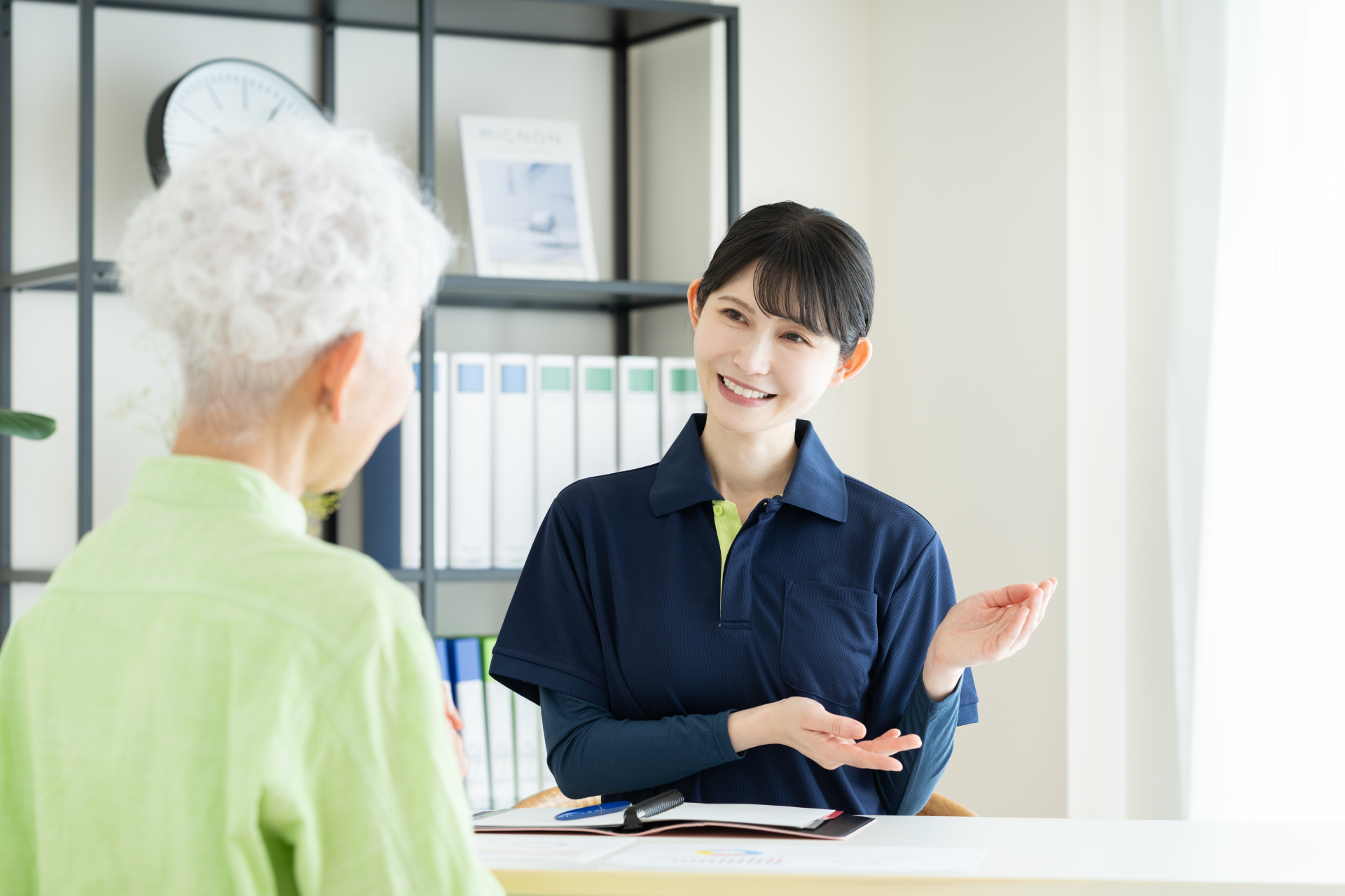 シニアの女性に説明する介護福祉士