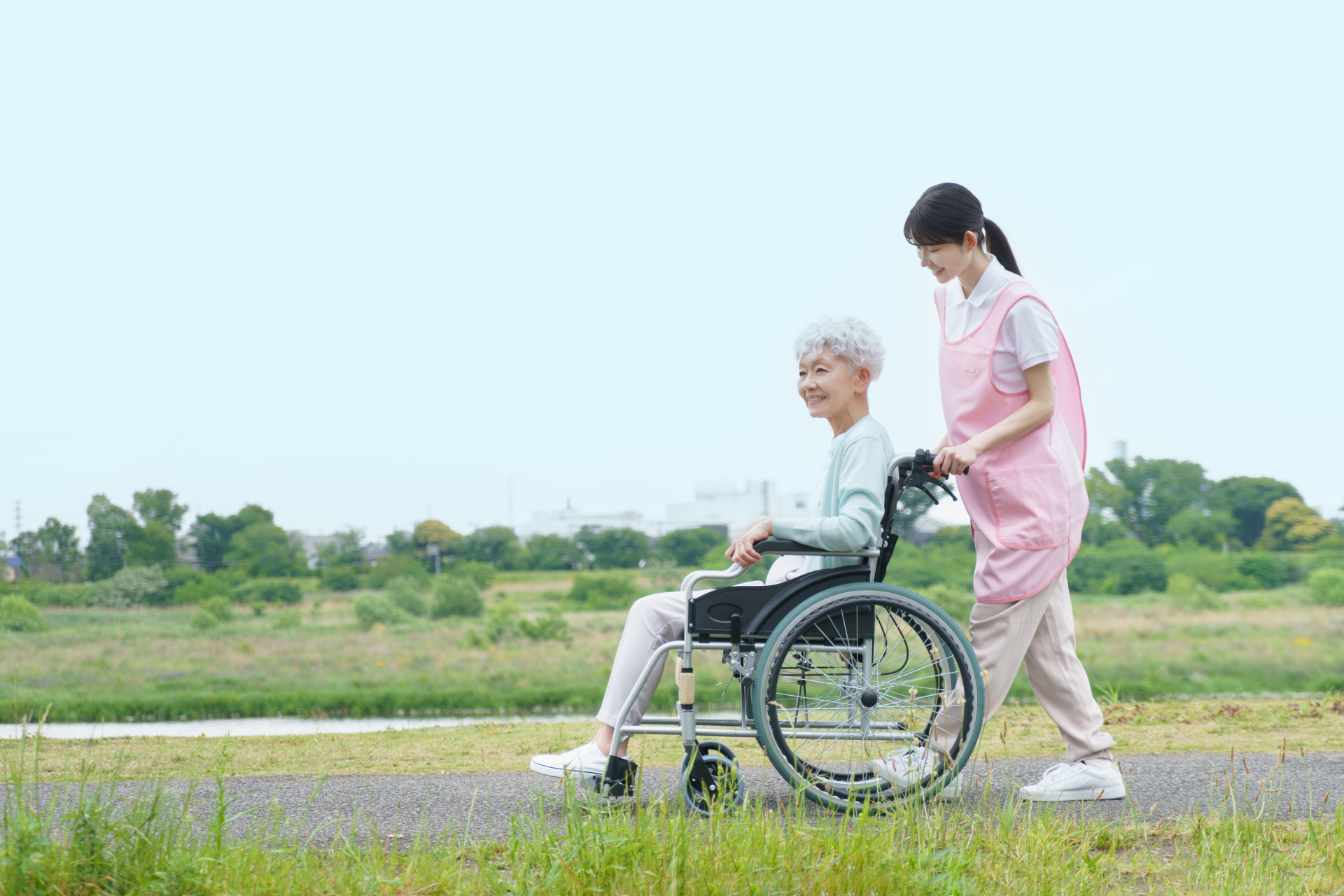車椅子のシニア女性と介護士の女性