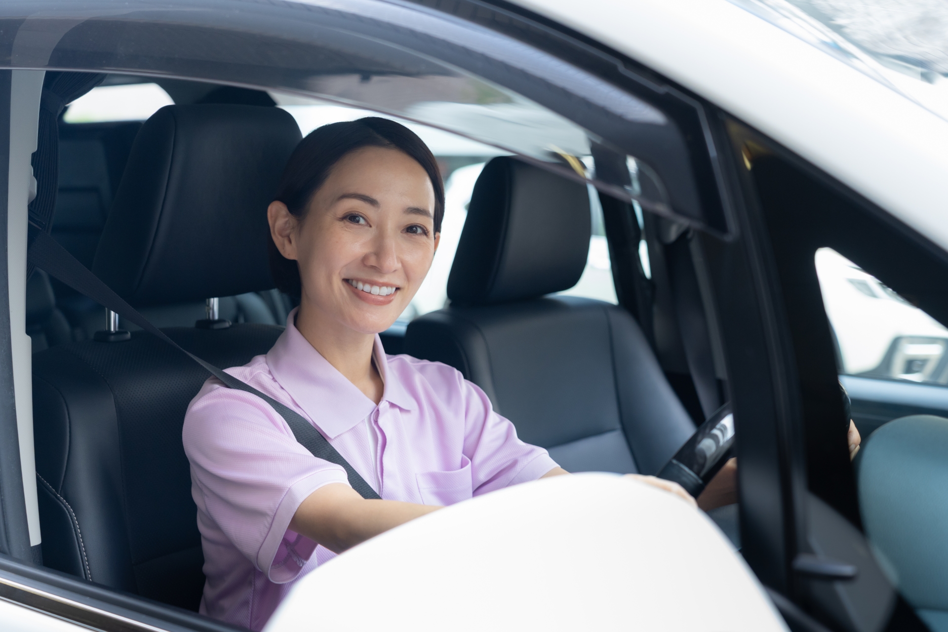 車で訪問介護をするミドルの女性介護士