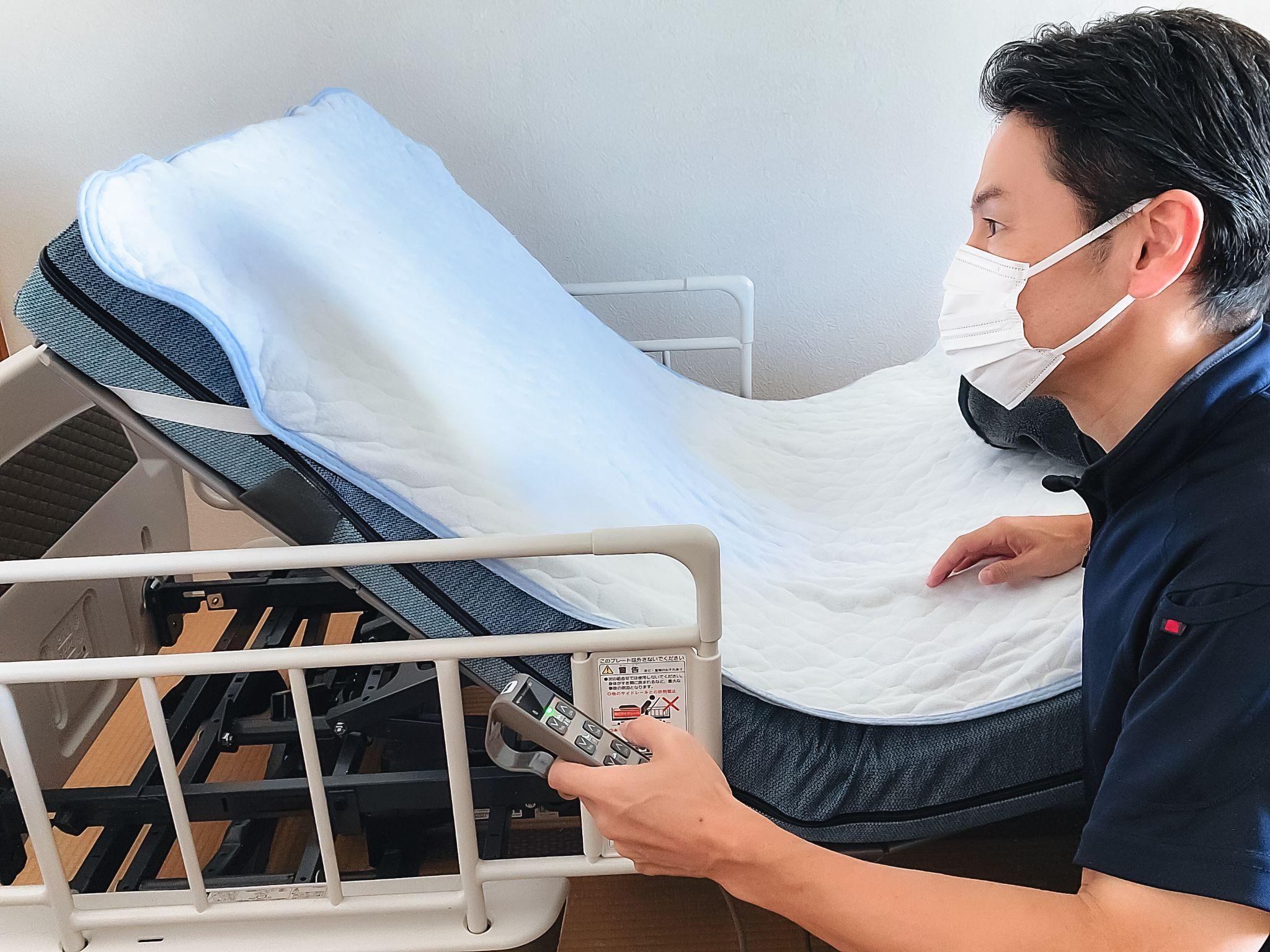 介護ベットの動作をチェックする介護士