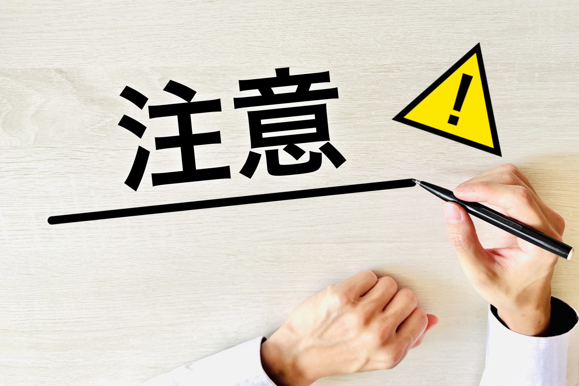 注意の文字を書く人の手
