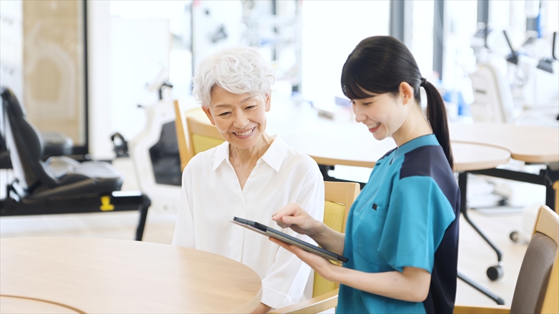 タブレットで健康チェックをする介護士