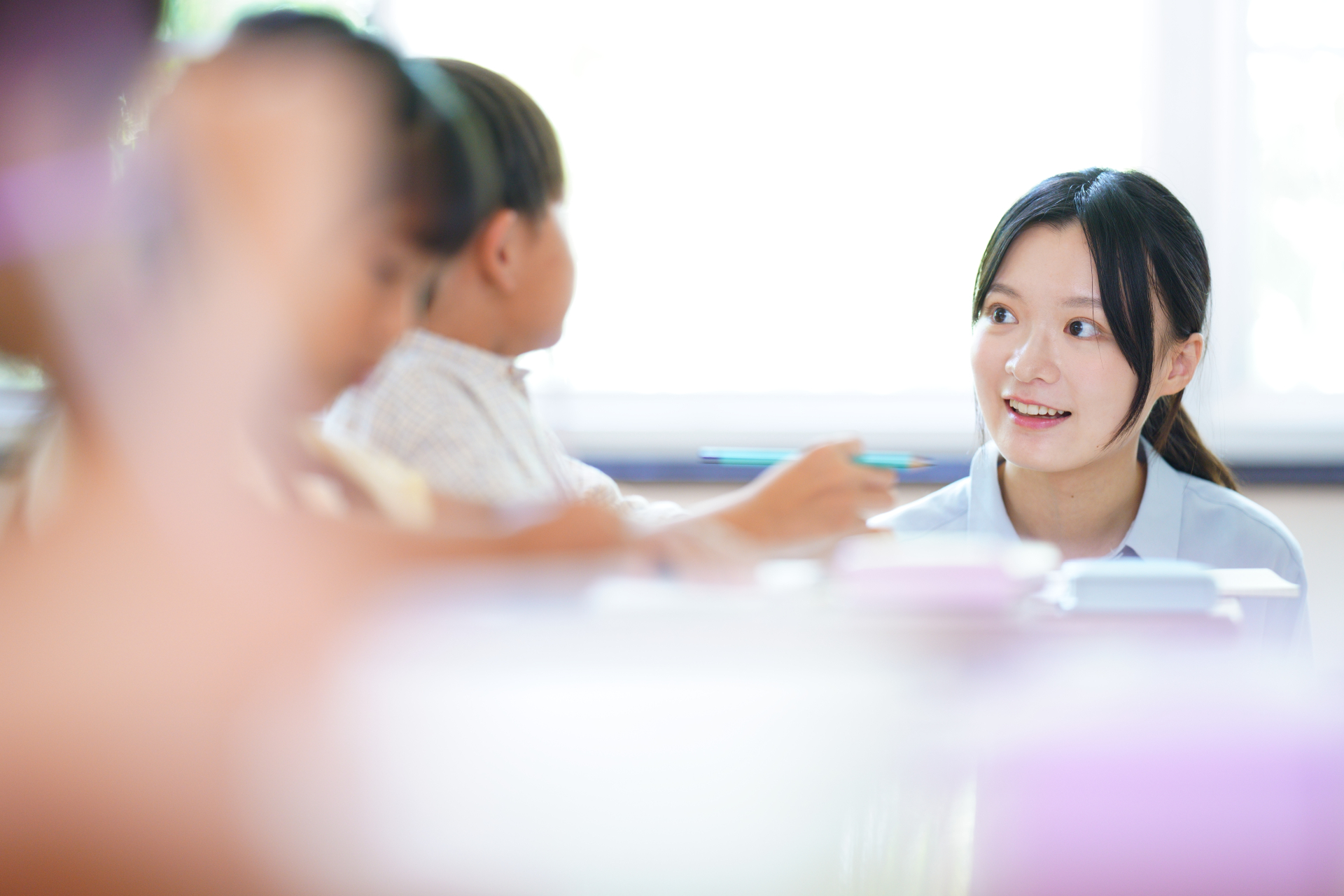 優しく話しかける先生と子ども