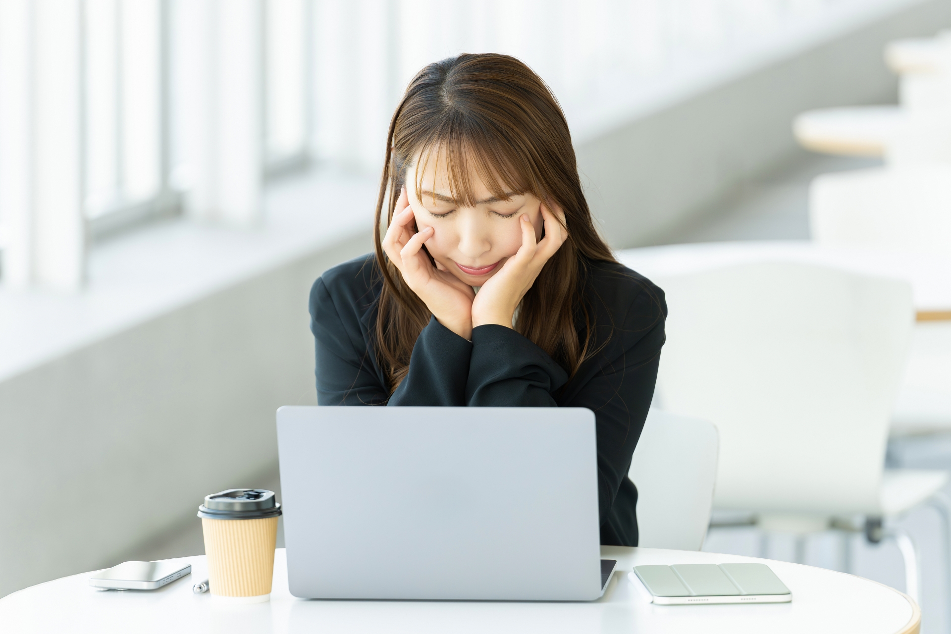パソコンを使いながら考える女性