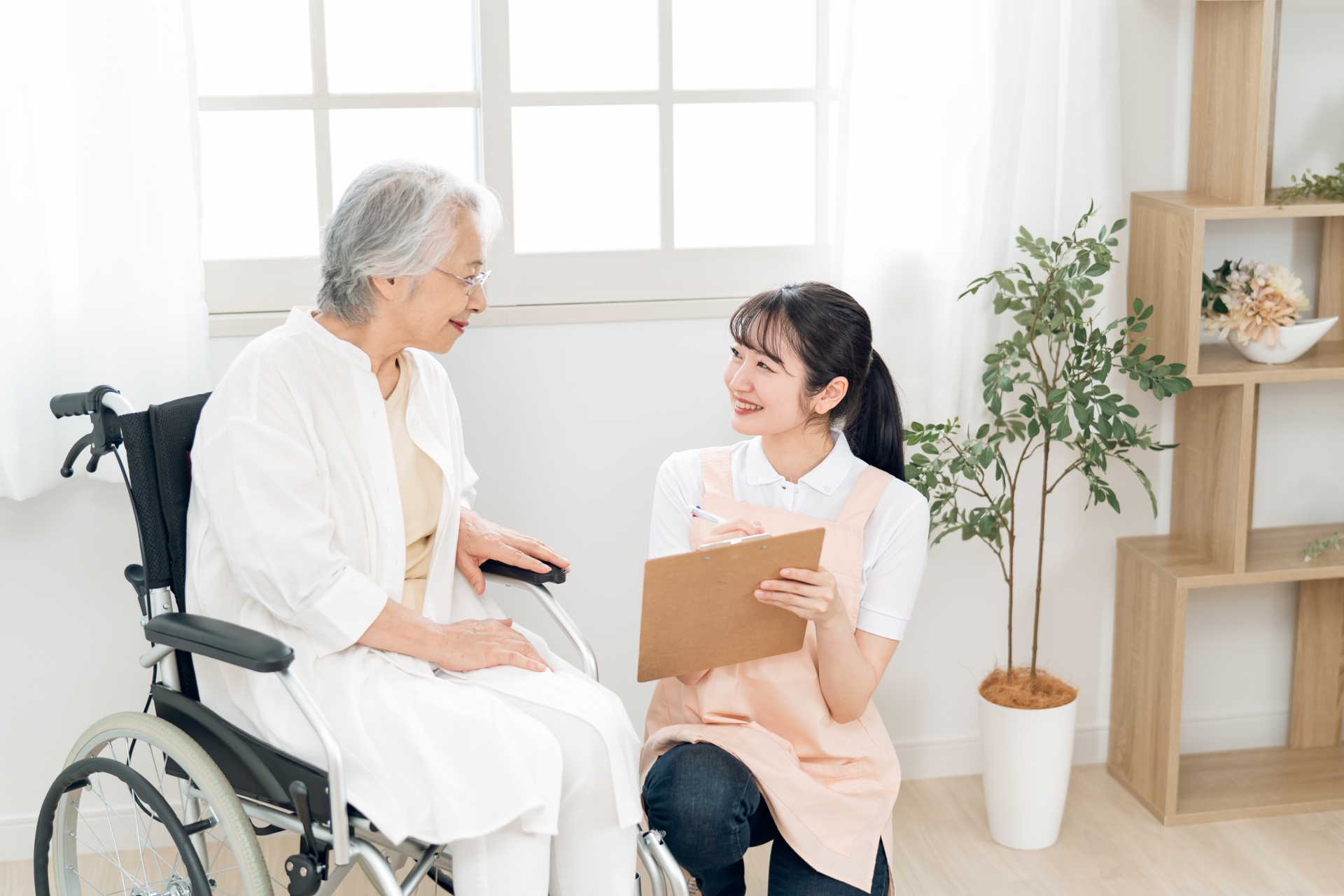 高齢者女性と話す介護士(メモ)