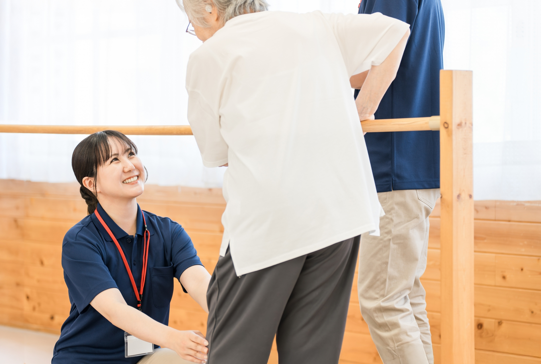 歩行訓練するシニア女性と介助するスタッフ
